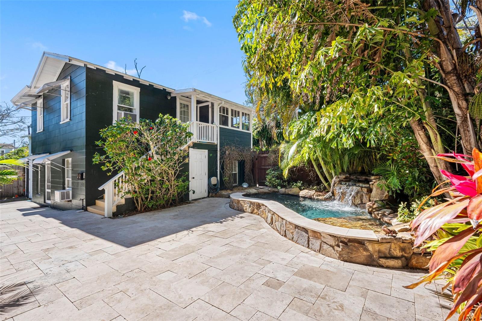 Back lanai with heated cocktail pool/spa and travertine pavers.