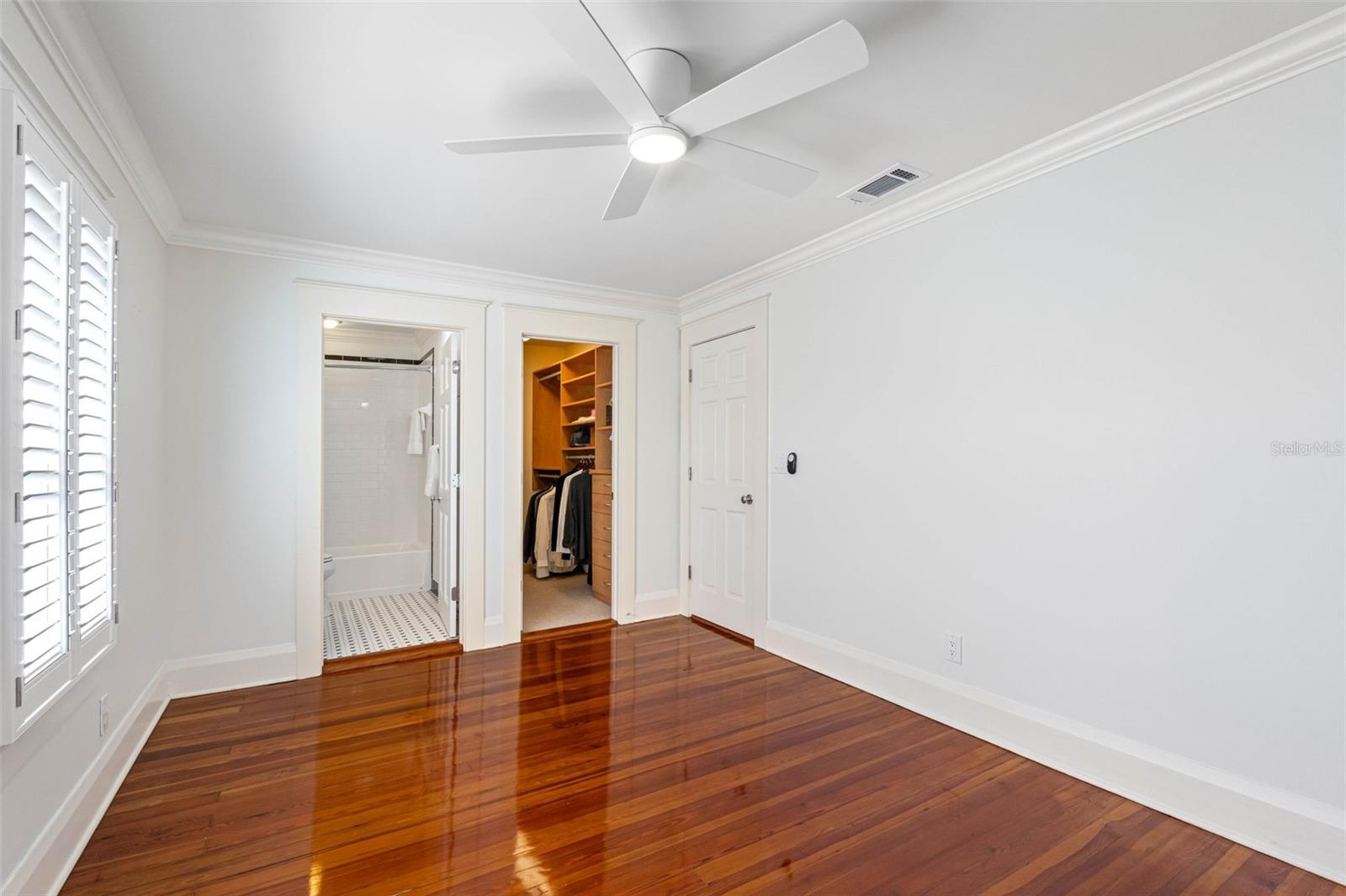 Bedroom #2 filled very luminous, with an en suit bathroom, walk-in closet, built-ins, plantation shutters, and ceiling fan.