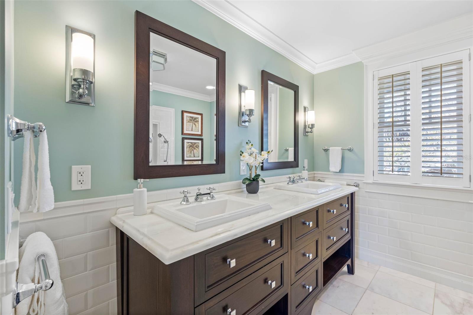 Master bathroom with marble floors and countertop, a dual-sink vanity, a glass shower and a soaking tub.