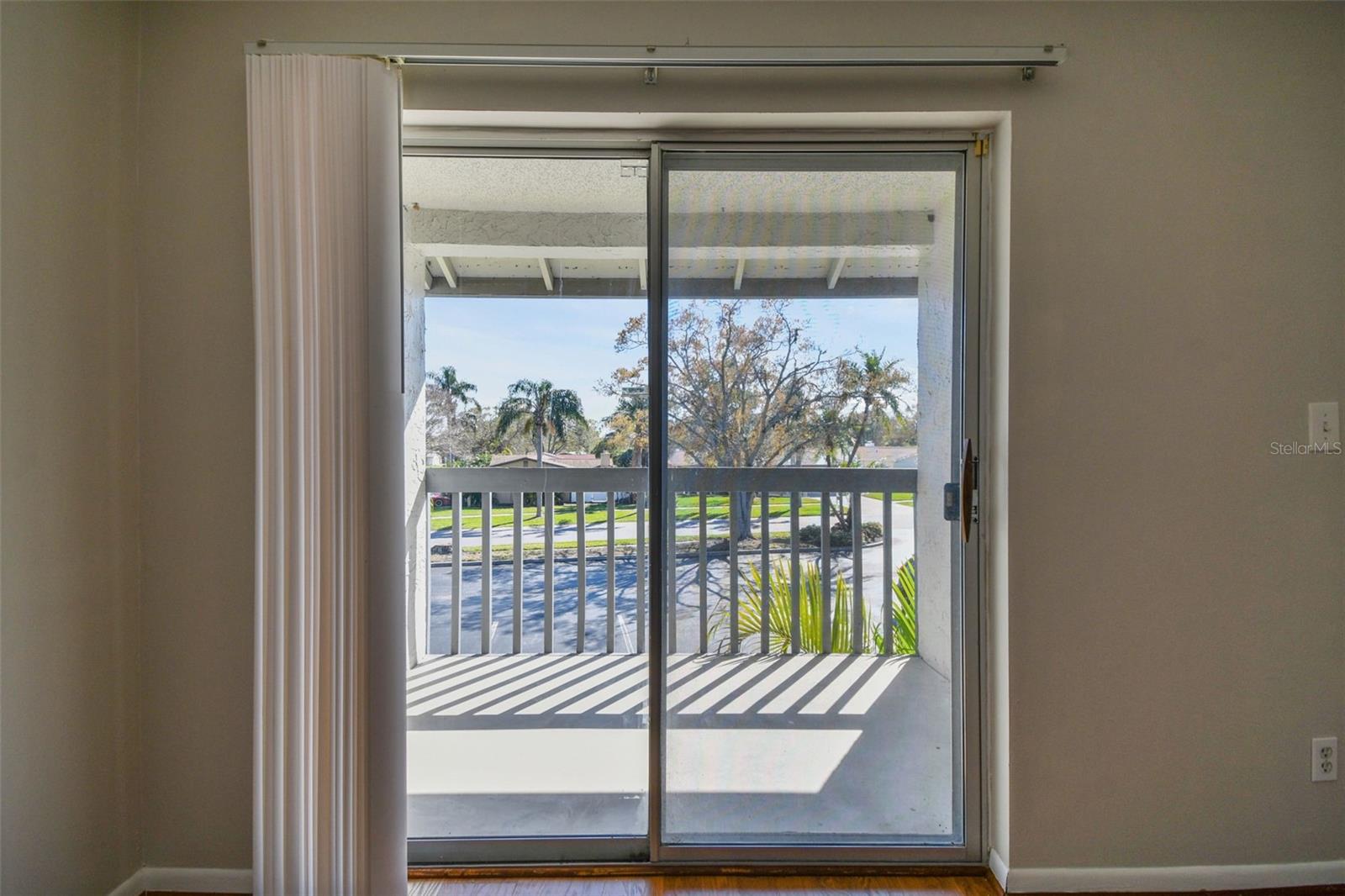 guest bedroom with double sliding glass doors and large screen.