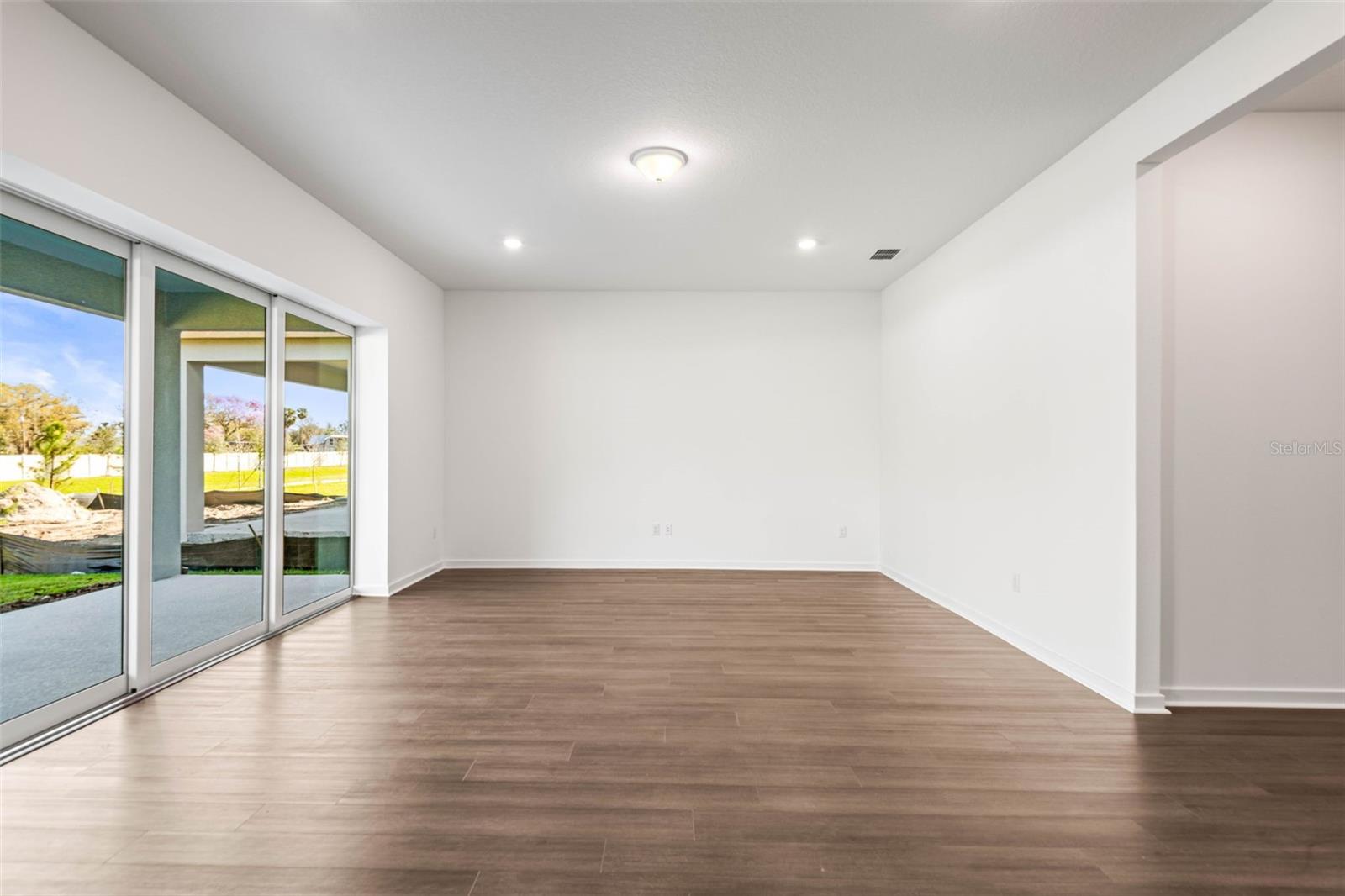 Living area with triple sliding glass pocket doors  (all doors slide behind wall) that open up to the covered lanai.
