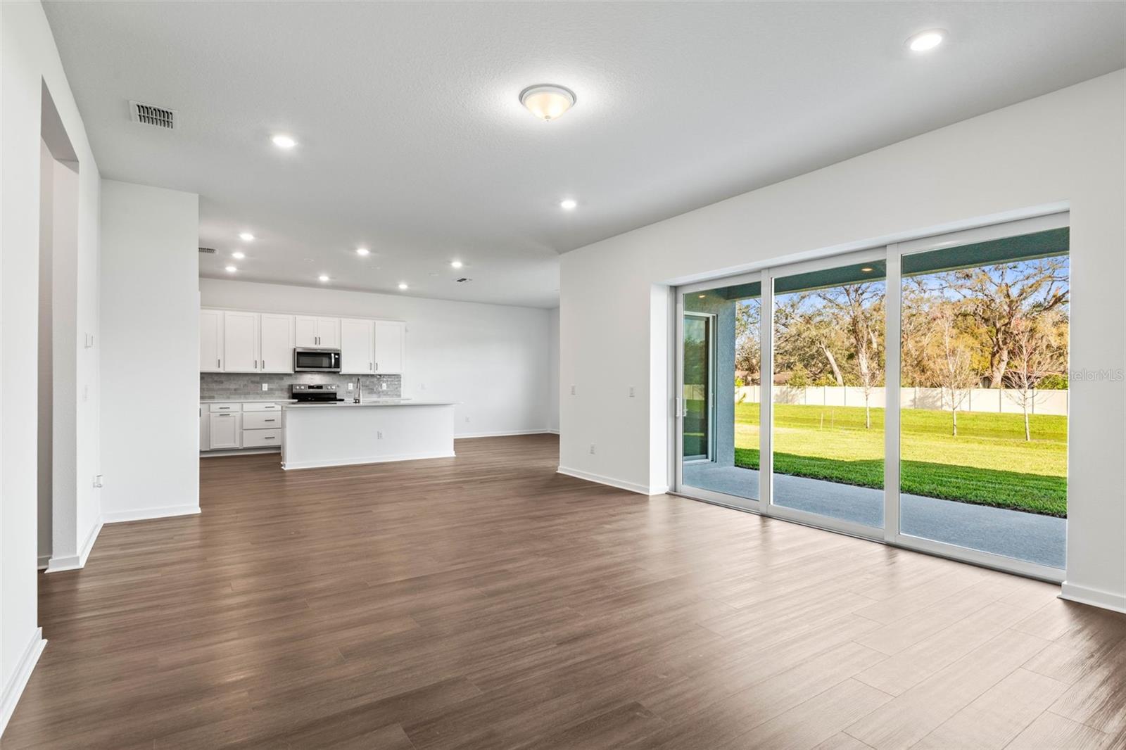 Living area, kitchen, dining area all overlook the covered lanai with pond view.