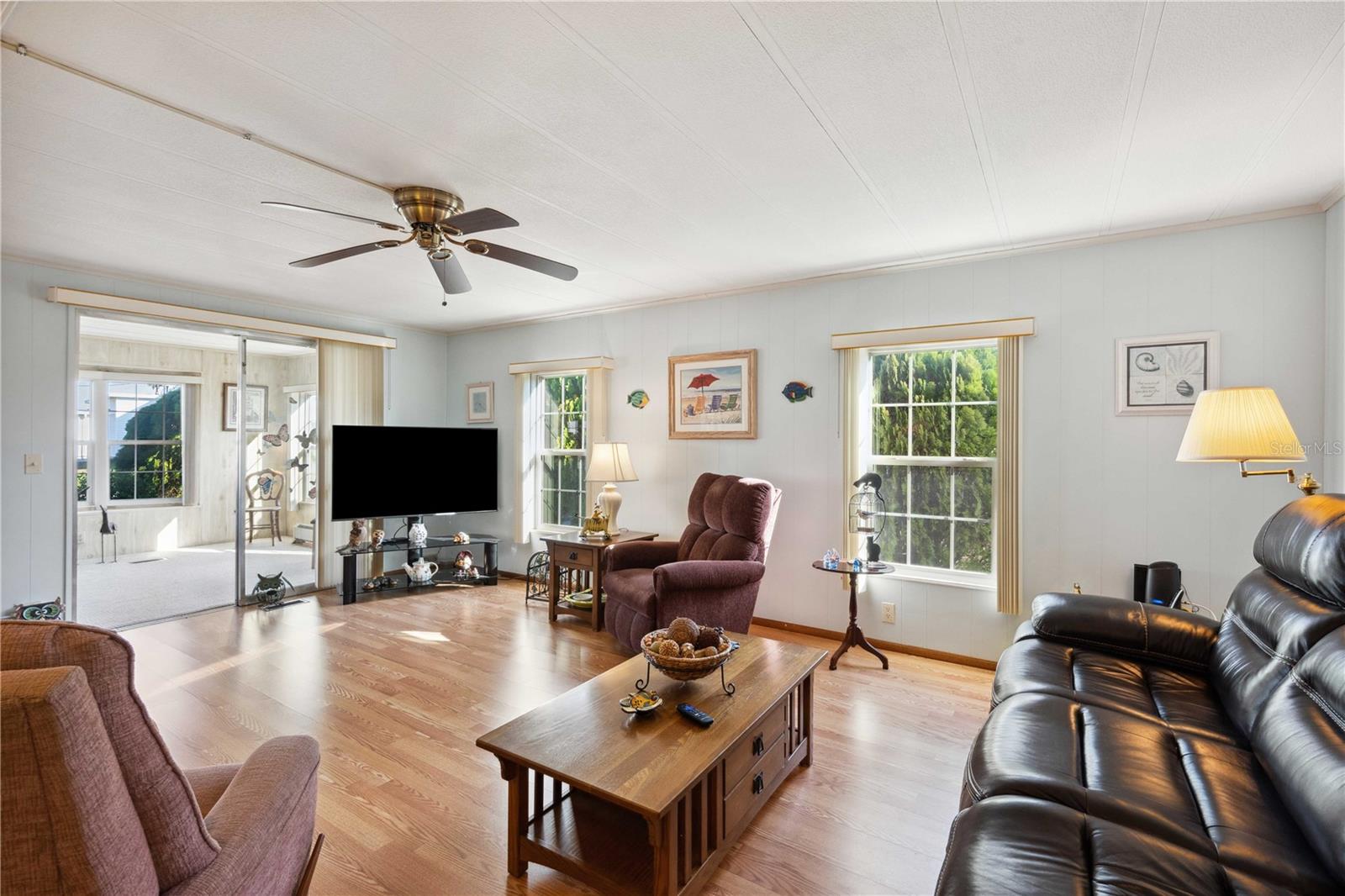 Living room has ceiling fan, laminate flooring and this home is fully furnished.