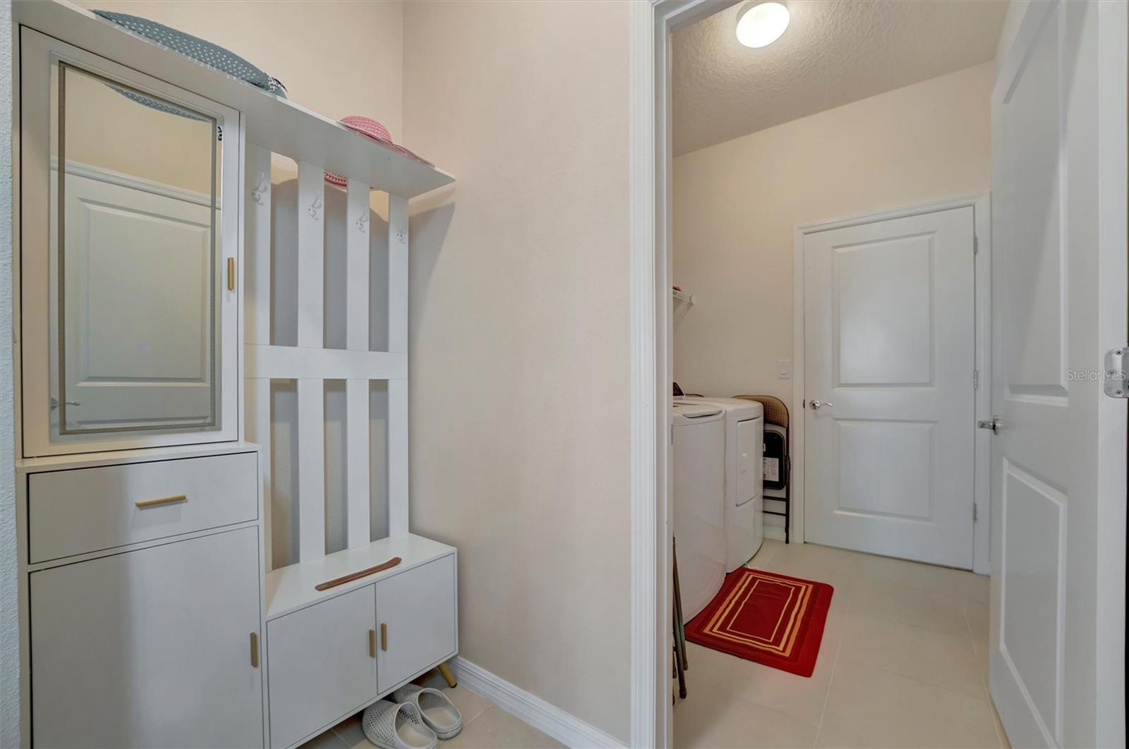 The Hallway to the right of the Foyer that leads to the laundry room, ALSO provides access to the Master Bedroom Closet.