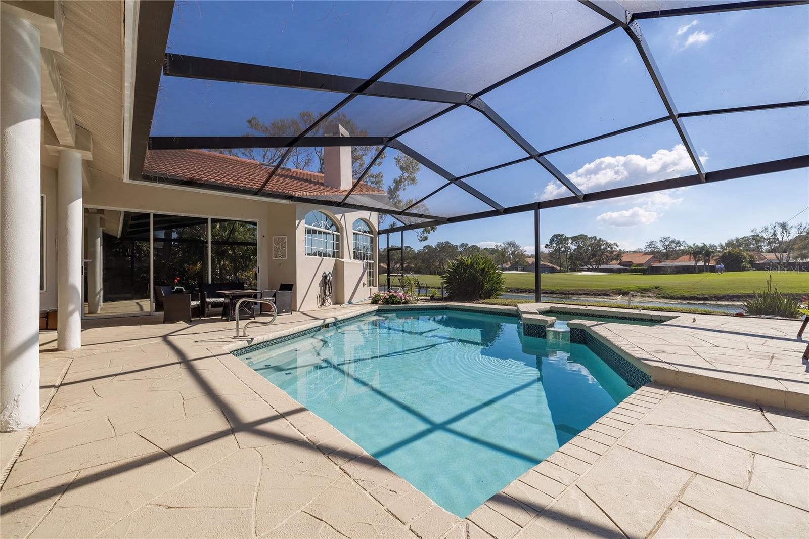 Expansive pool deck with heated swimming pool and spa