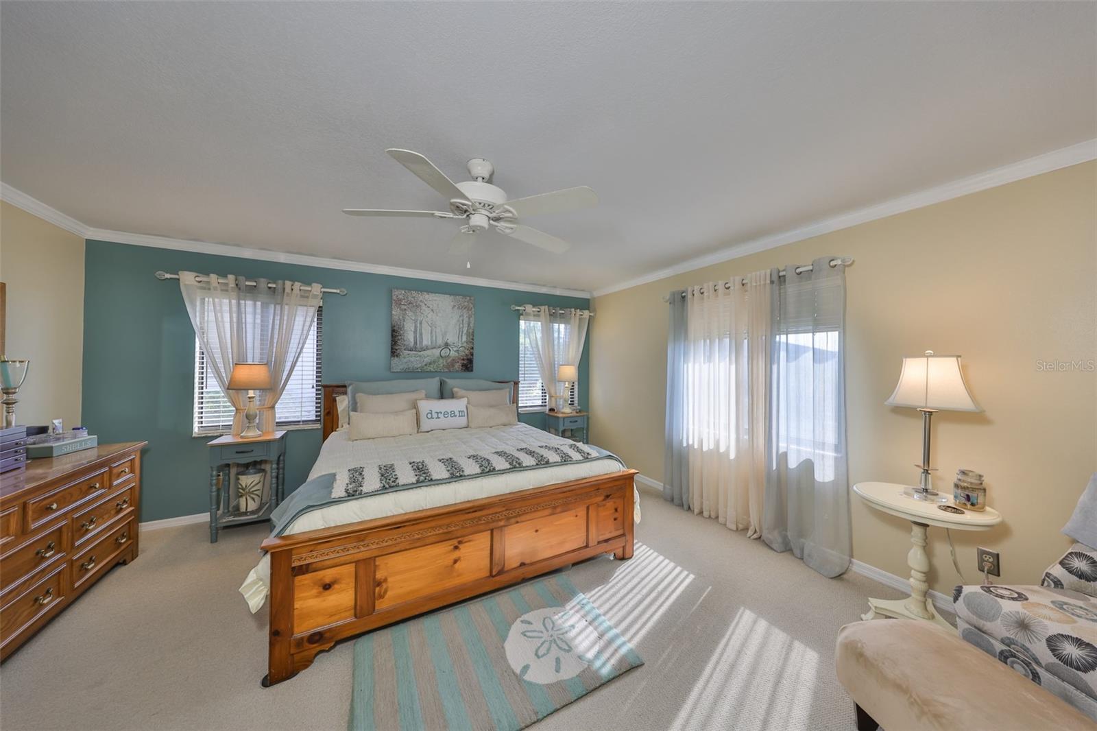 Primary bedroom is large and spacious with crown molding and neutral point tones.