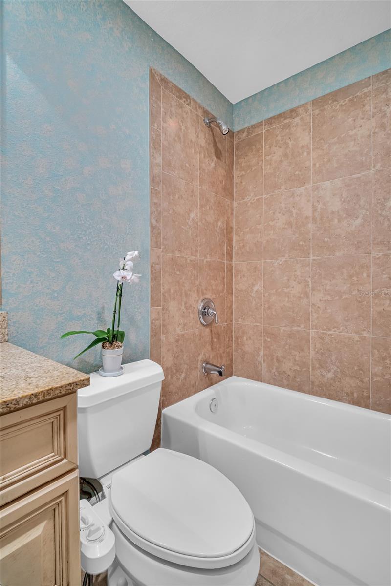 Second bath features a single vanity and a shower/tub combo.