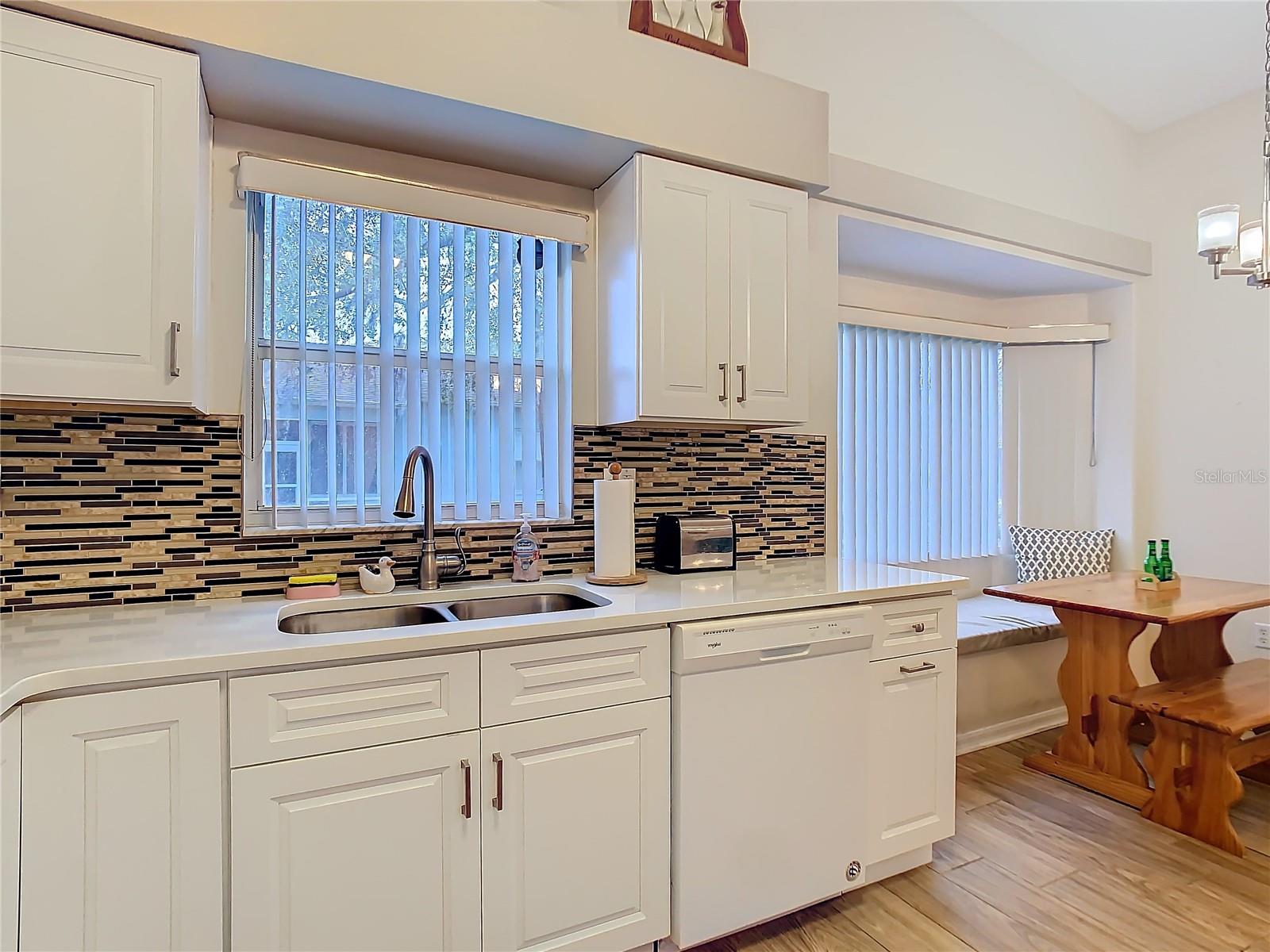 The deep double sink gives you a view of the back yard and allows for a lot of natural light as well. The dishwasher was purchased in 2023.