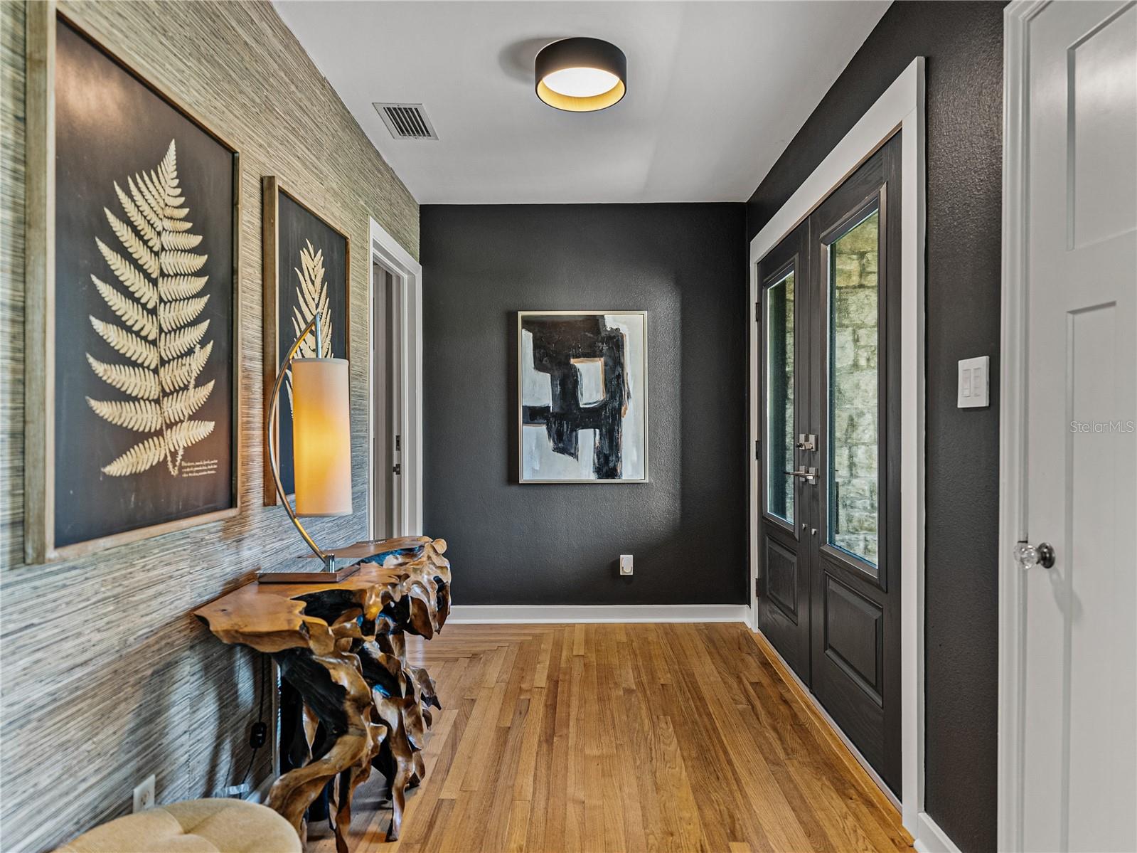 Original hardwood floors, complemented by chic grasscloth entry wall.