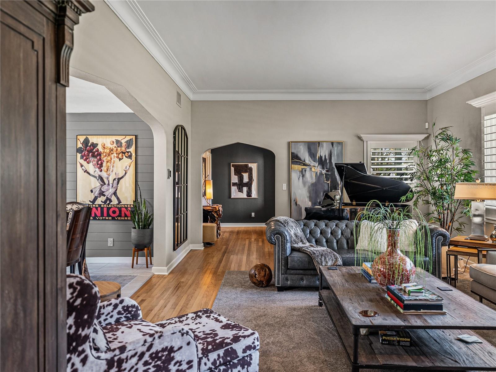 The enormous living room, with high ceilings, crown molding, original hardwood floors and plantation shutters is cozy and inviting, and perfect for entertaining.