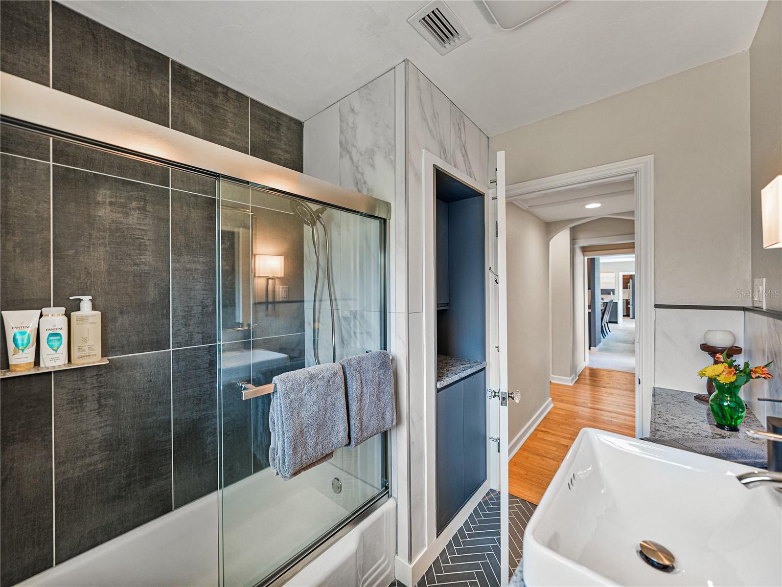 Guest bathroom with tub/shower combination and plenty of countertop and storage space.