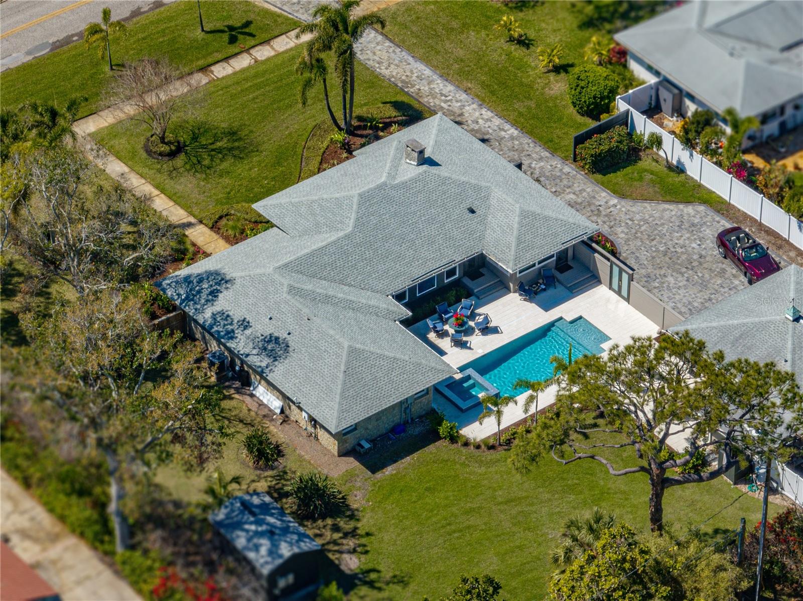 Aerial view of 2025 paver driveway, 2024 pool & spa, and massive yard and shell stone patio.