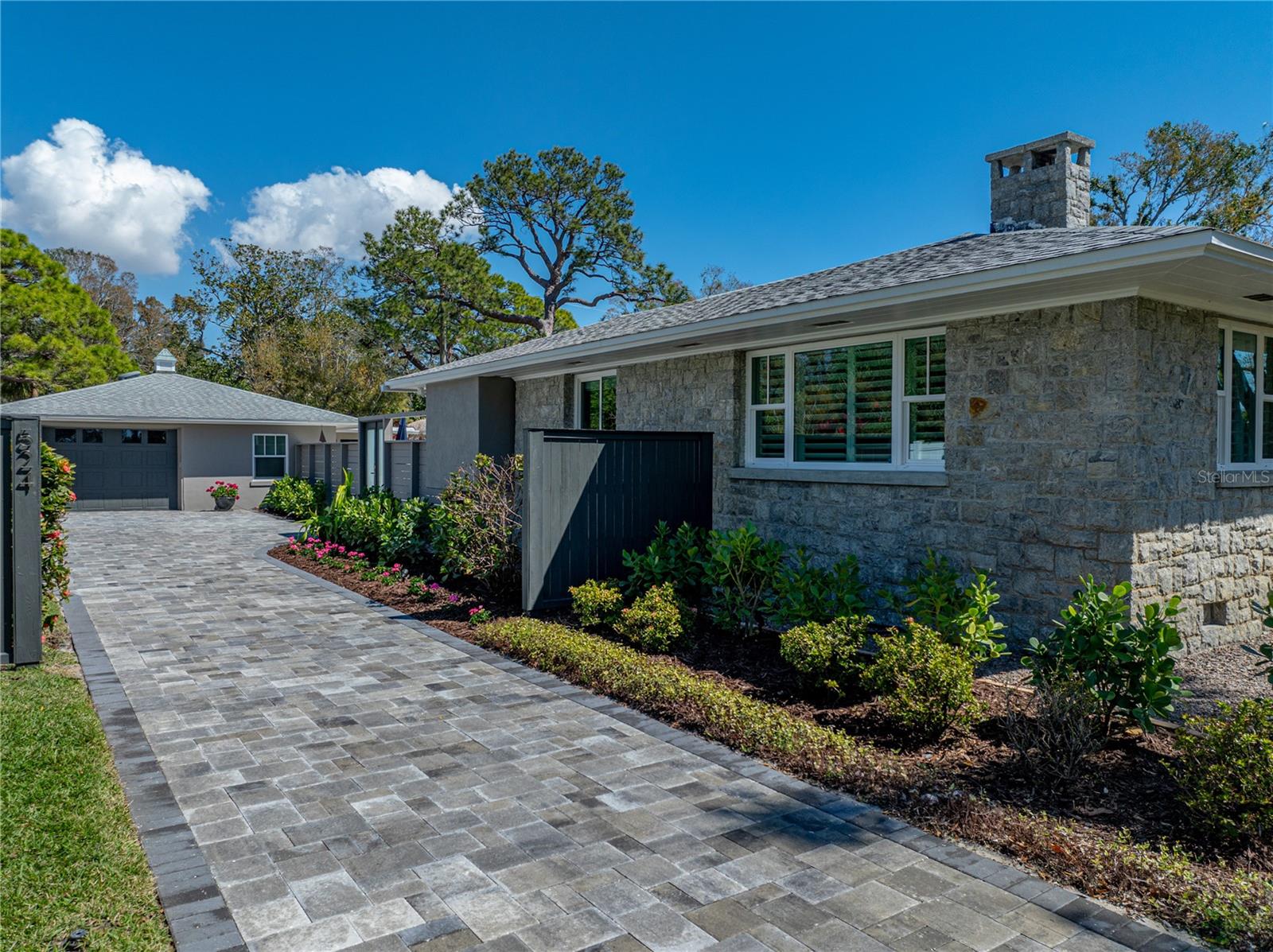 2025 Paver driveway with access to the single car garage and gravel pull-through spanning the length of the property.