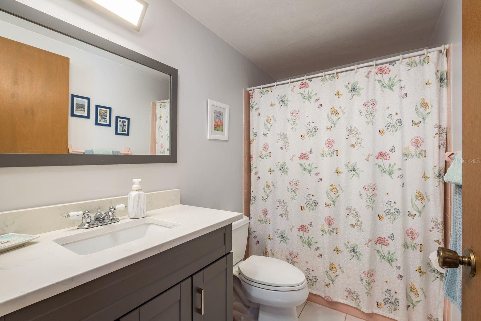 Full, nicely updated bathroom with tub & shower is conveniently next to the bedrooms.