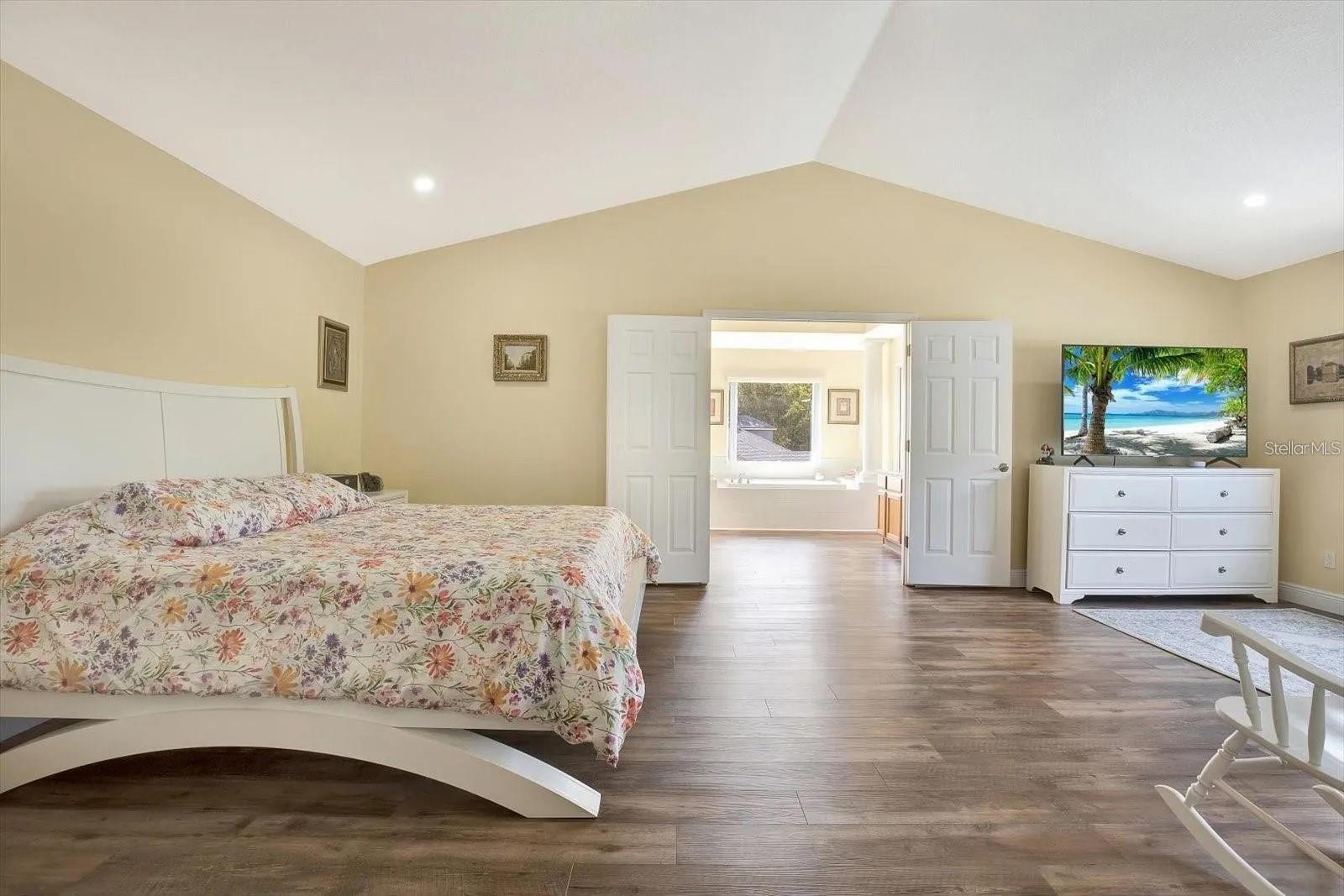 Grand master bedroom with double doors into master bath