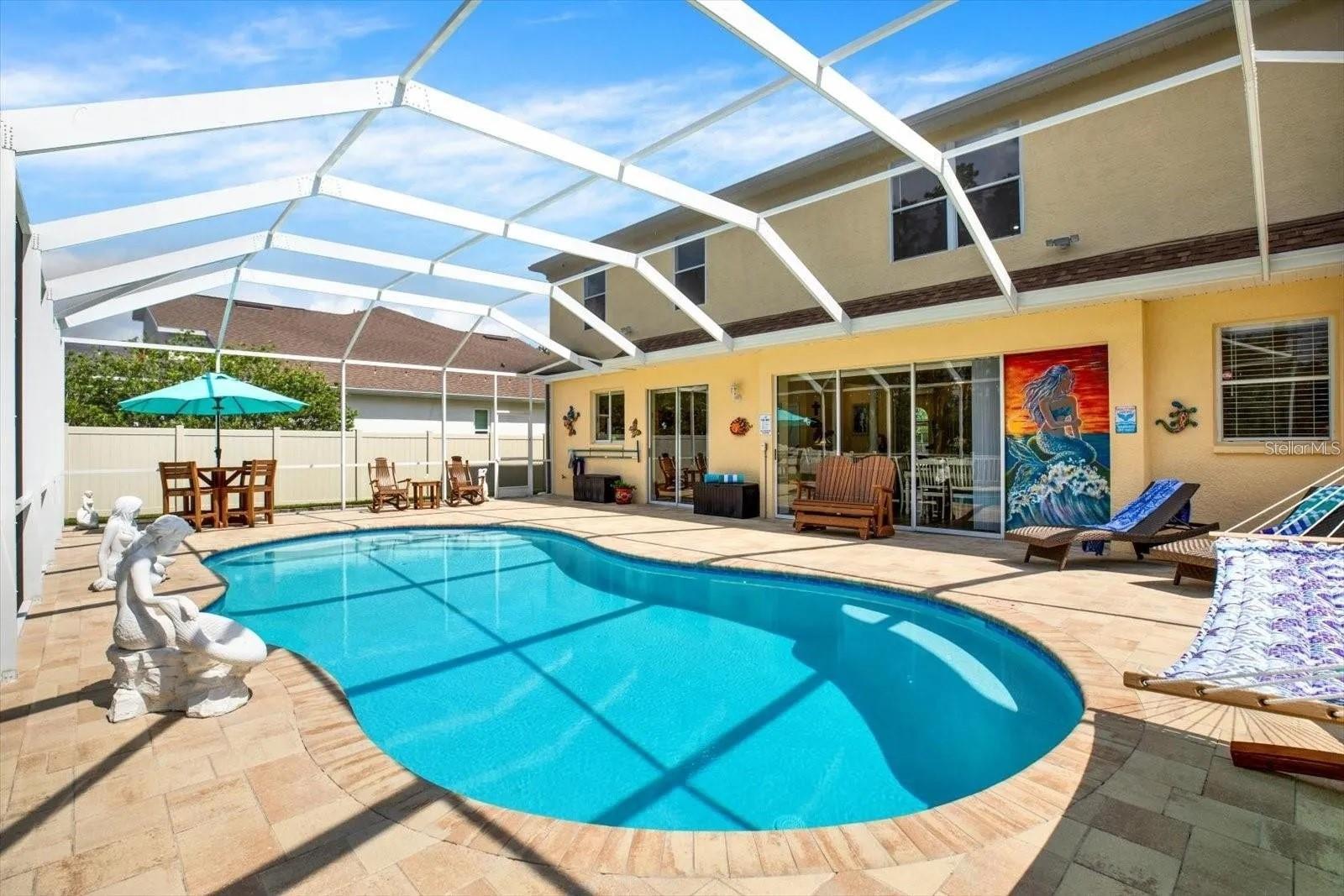 Fully screened heated salt water pool with double patio doors on opposite sides for easy access to backyard