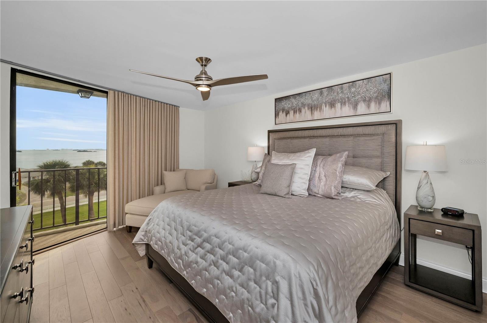 Primary Bedroom with great water views and exquisite taste in furnishings!  All new solid wood flooring, high base boards, soft drapes, king size bed, and end tables, sofiscated art work throughout!