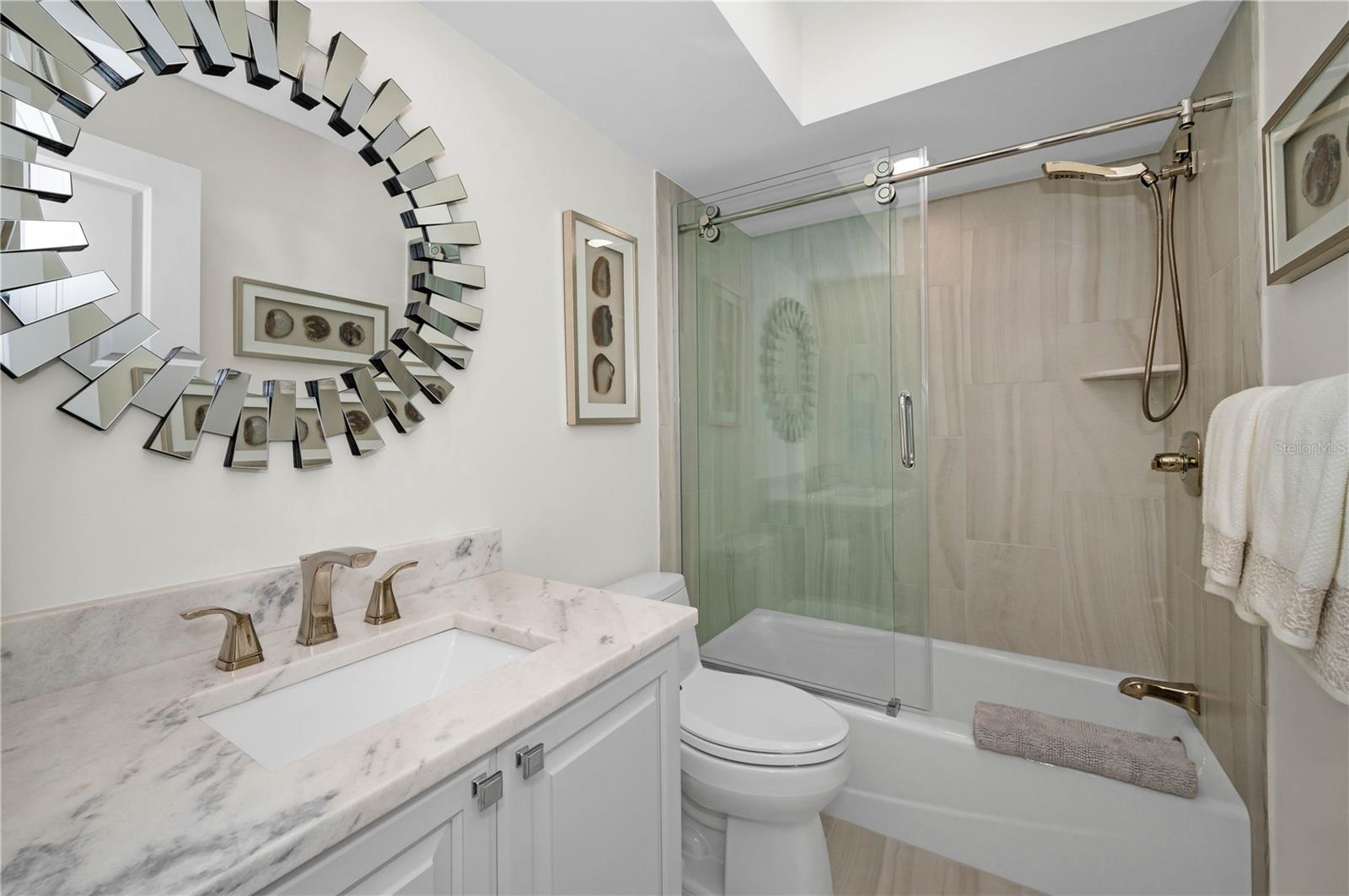 Second Bathroom with tub and shower.  Beautiful vanity and mirror, and gold faucets, and gold tub attachments that will dazzle your guests.  Touch sliding rollers for ease in opening and closing your shower doors.