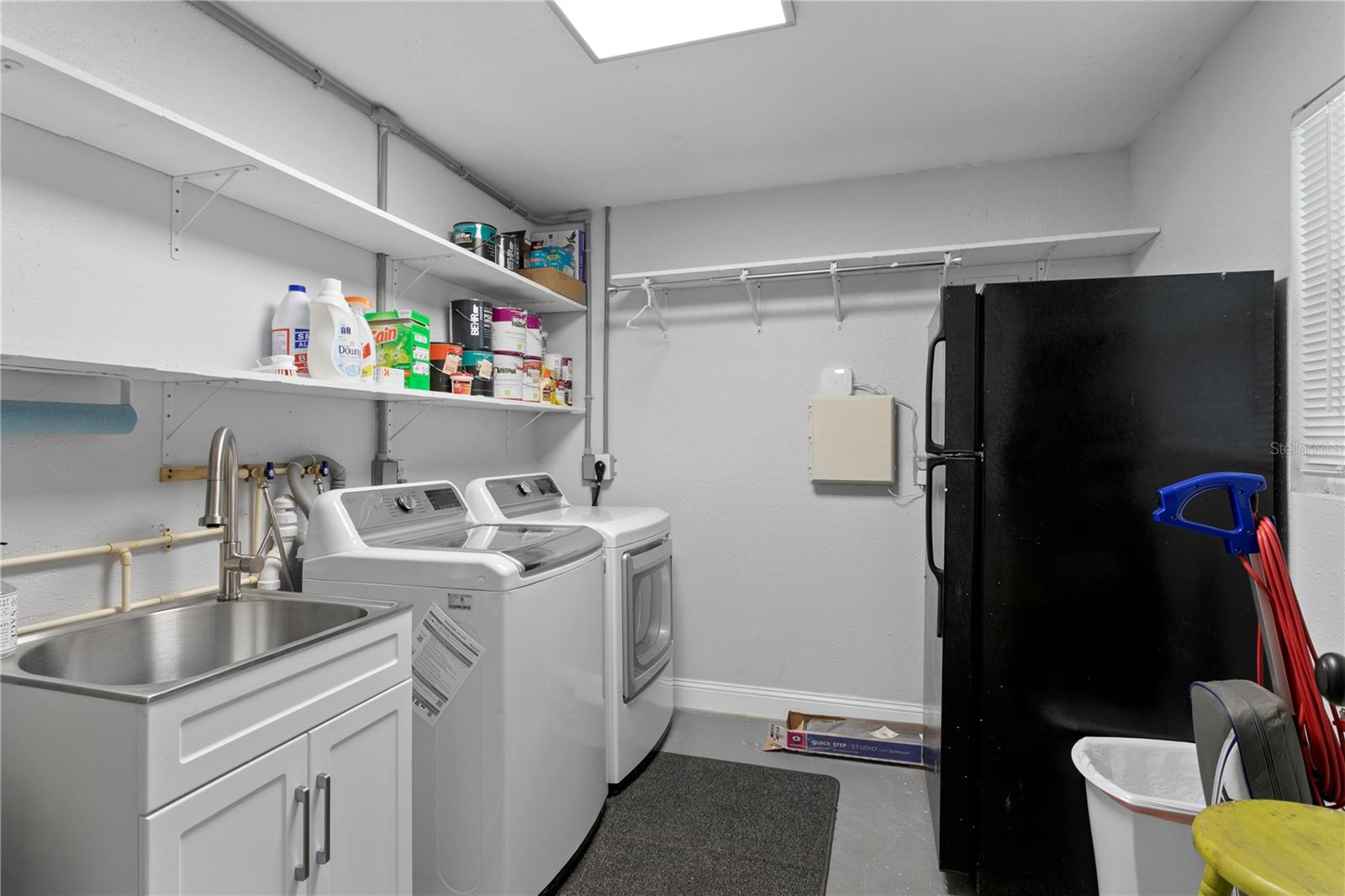 Utility room including sink, secondary refrigerator, and loads of storage