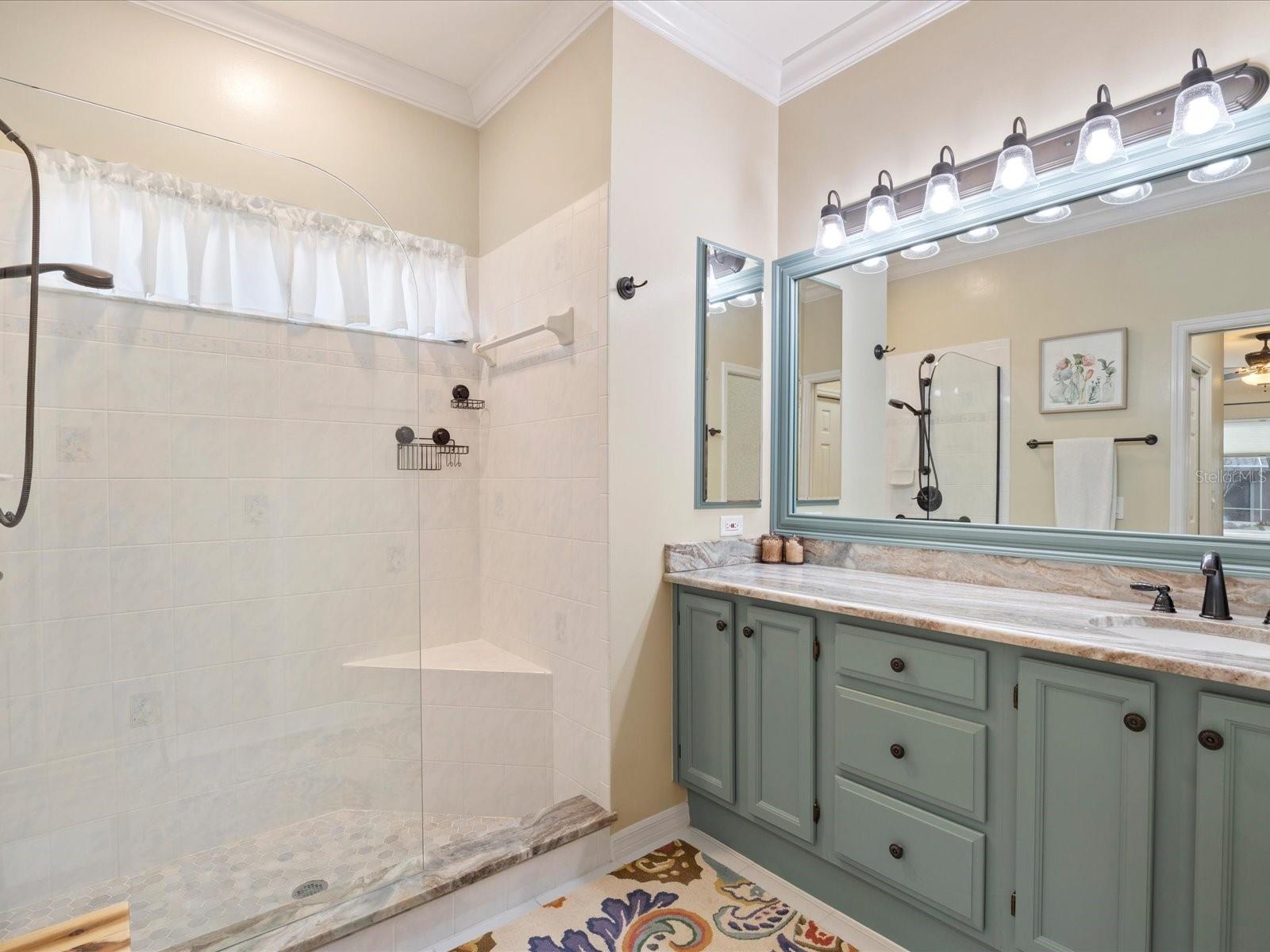 Primary bathroom with seamless glass shower and bench