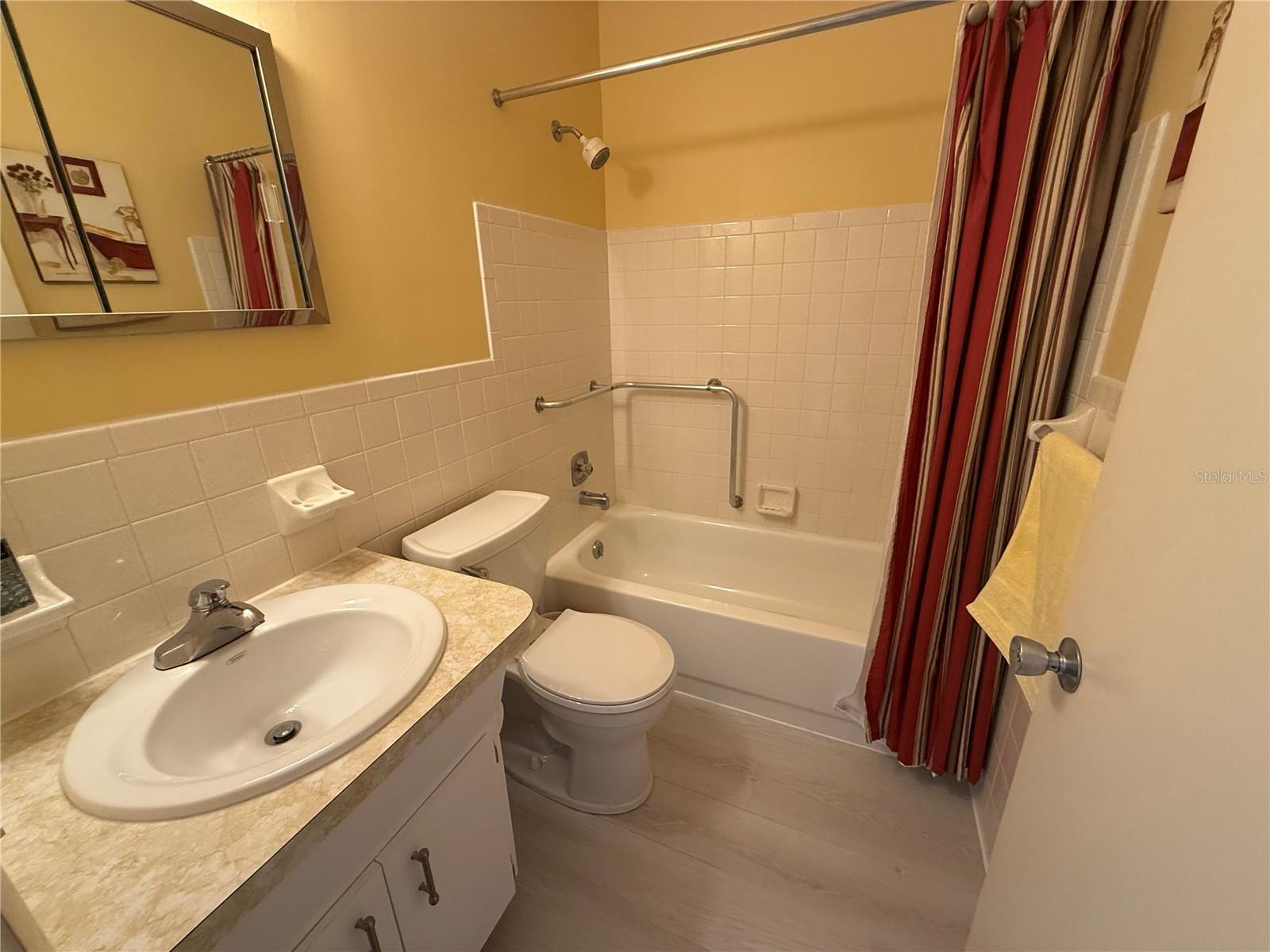 Guest bath with shower/tub combo and newer toilet and vinyl flooring