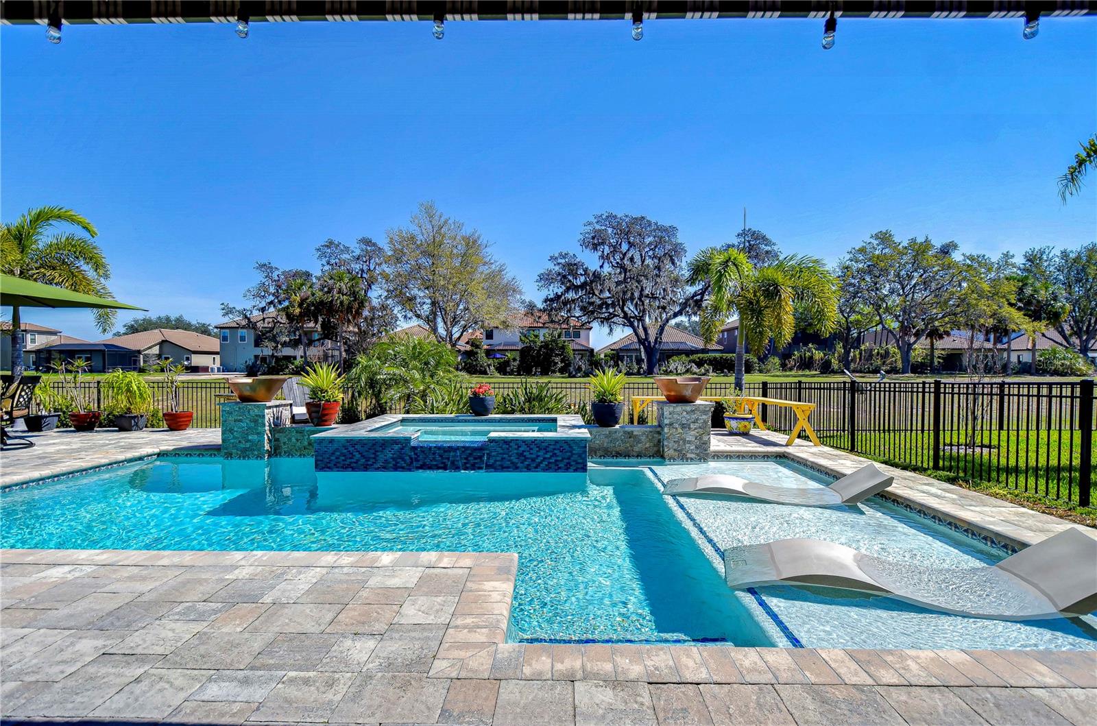 Bask in luxury with this stunning pool area, complete with a spa and sunbathing ledge