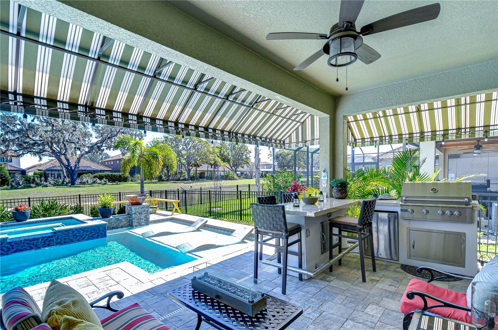 Dive into outdoor bliss with this stunning patio, featuring a sparkling pool and a sleek outdoor kitchen.