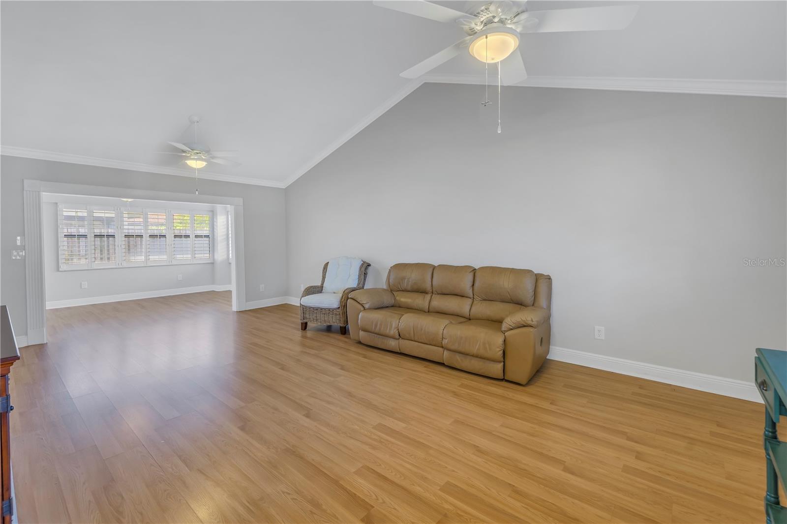 Great Room With Crown Molding And Vaulted Ceilings