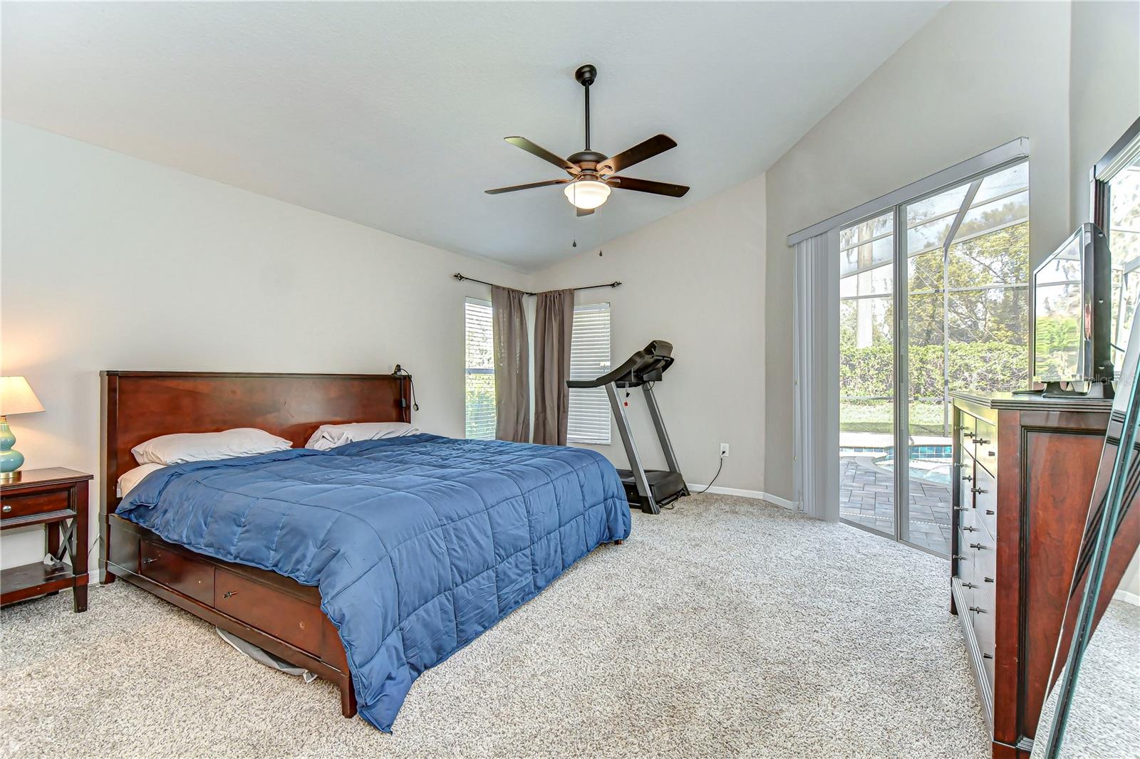 Unwind in this inviting primary bedroom with tranquil pool views.