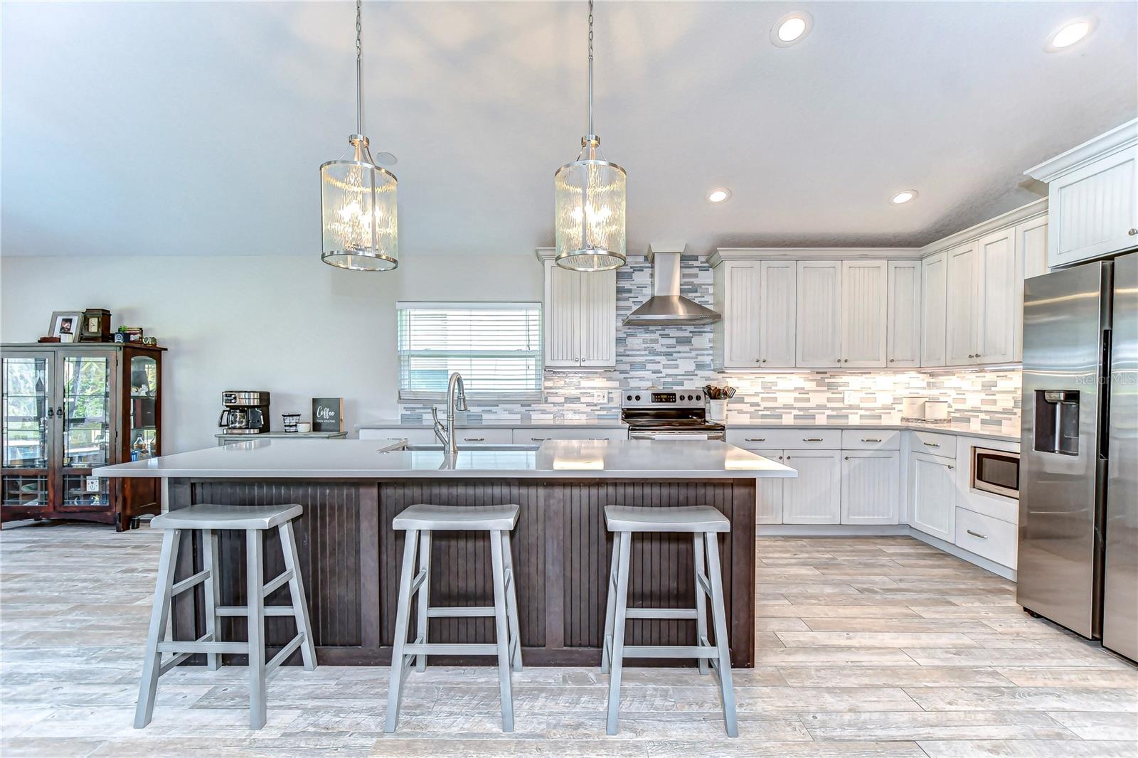 This stylish kitchen boasts sleek stainless steel appliances, a spacious island for culinary creativity, and elegant pendant lighting.