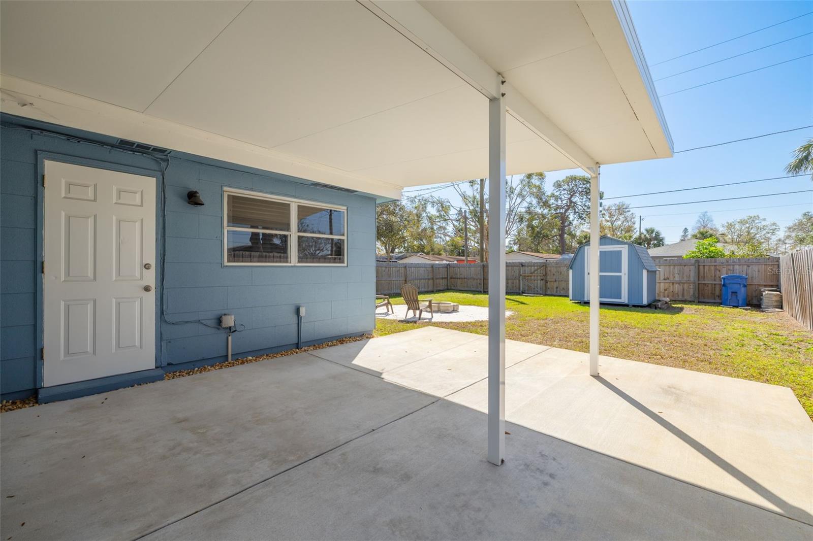 Rear covered patio opens up to huge backyard