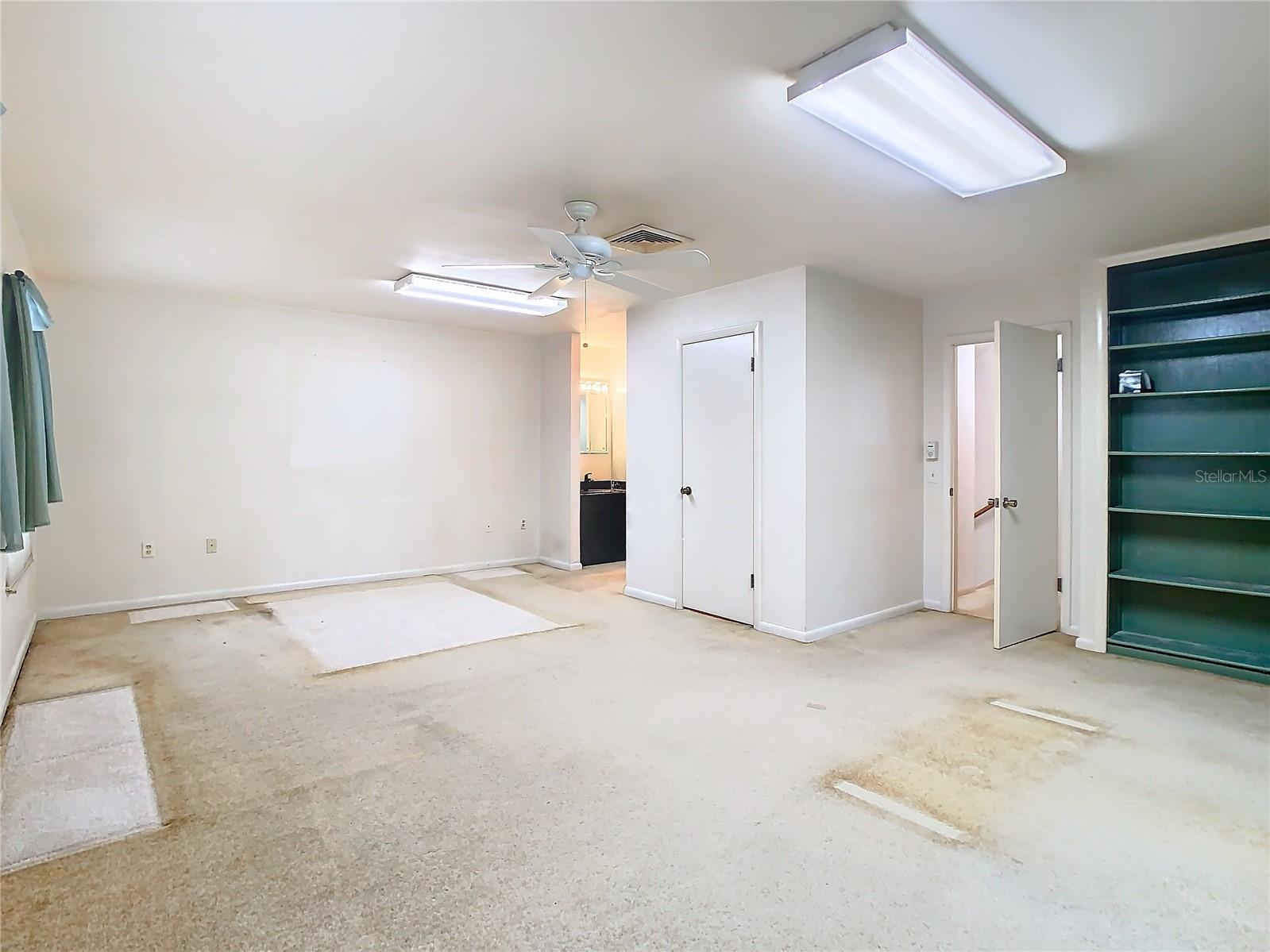 Spacious primary bedroom upstairs with built in shelving