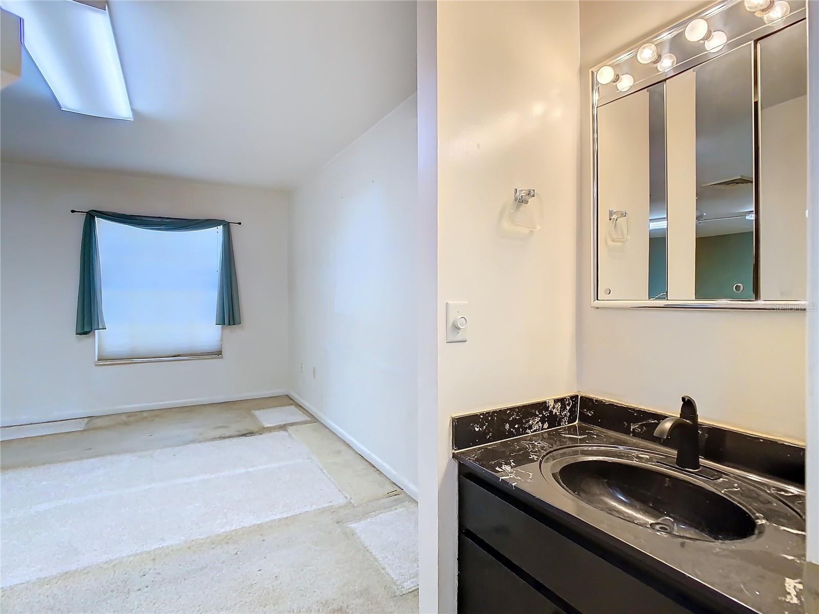 Primary ensuite vanity looking into bedroom