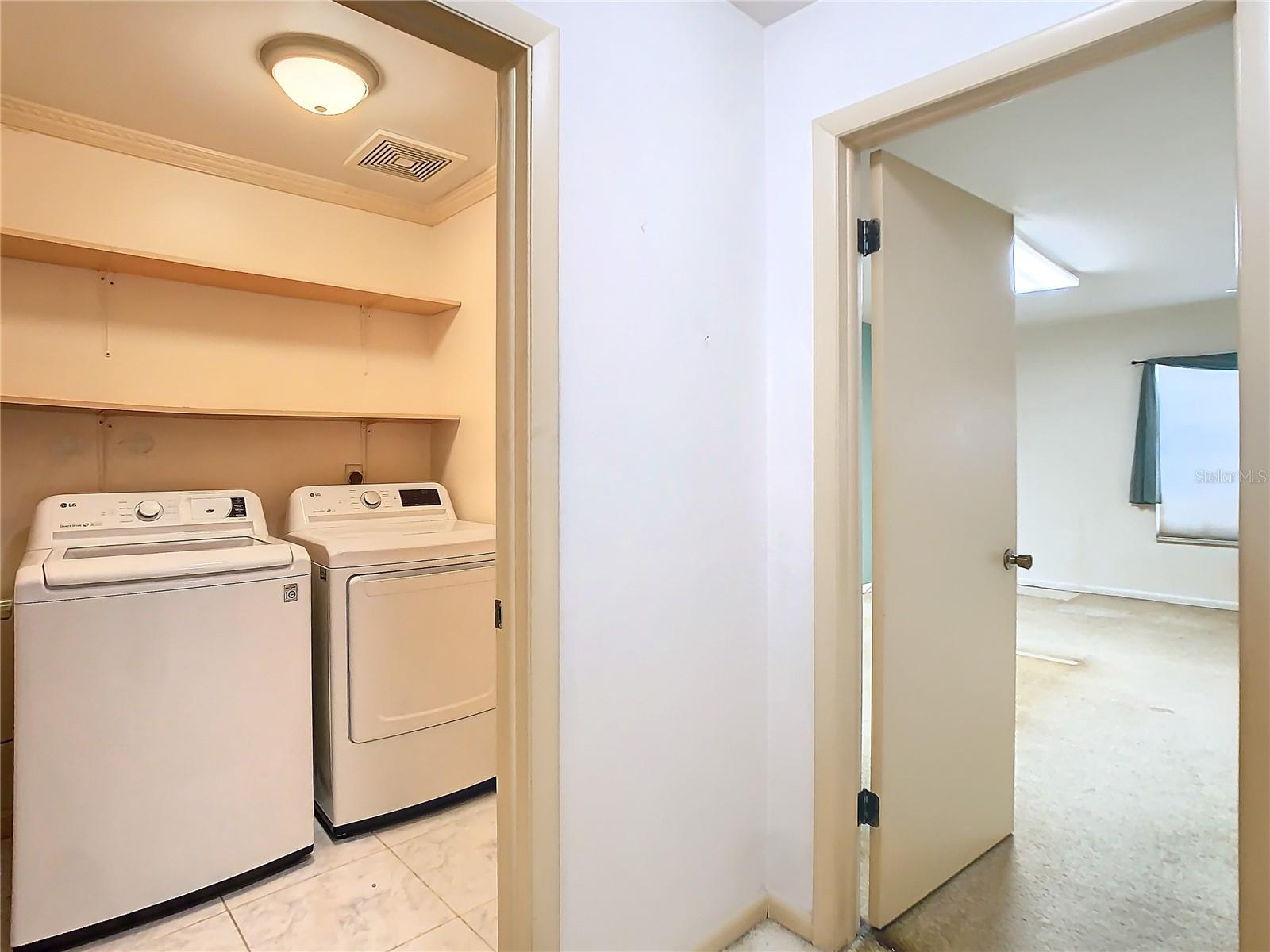 Laundry room and primary doorway view from stairway