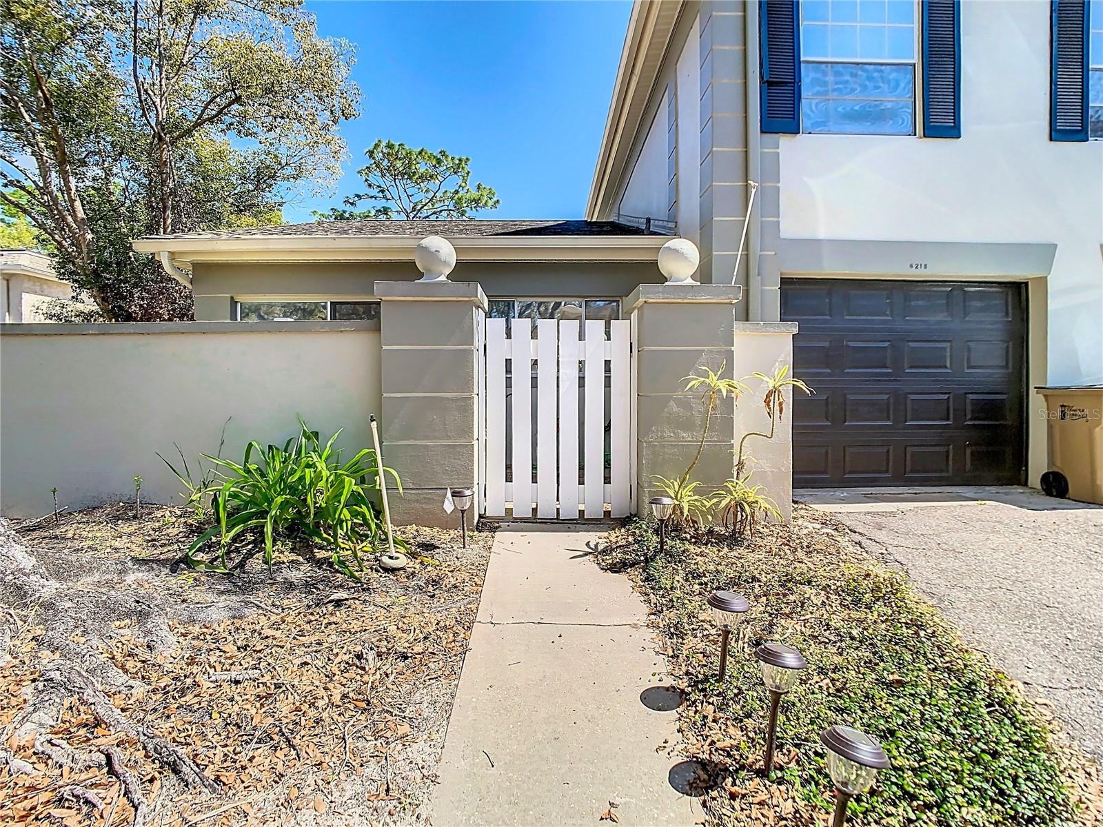 Exterior walkway to attached garage and private courtyard with gate