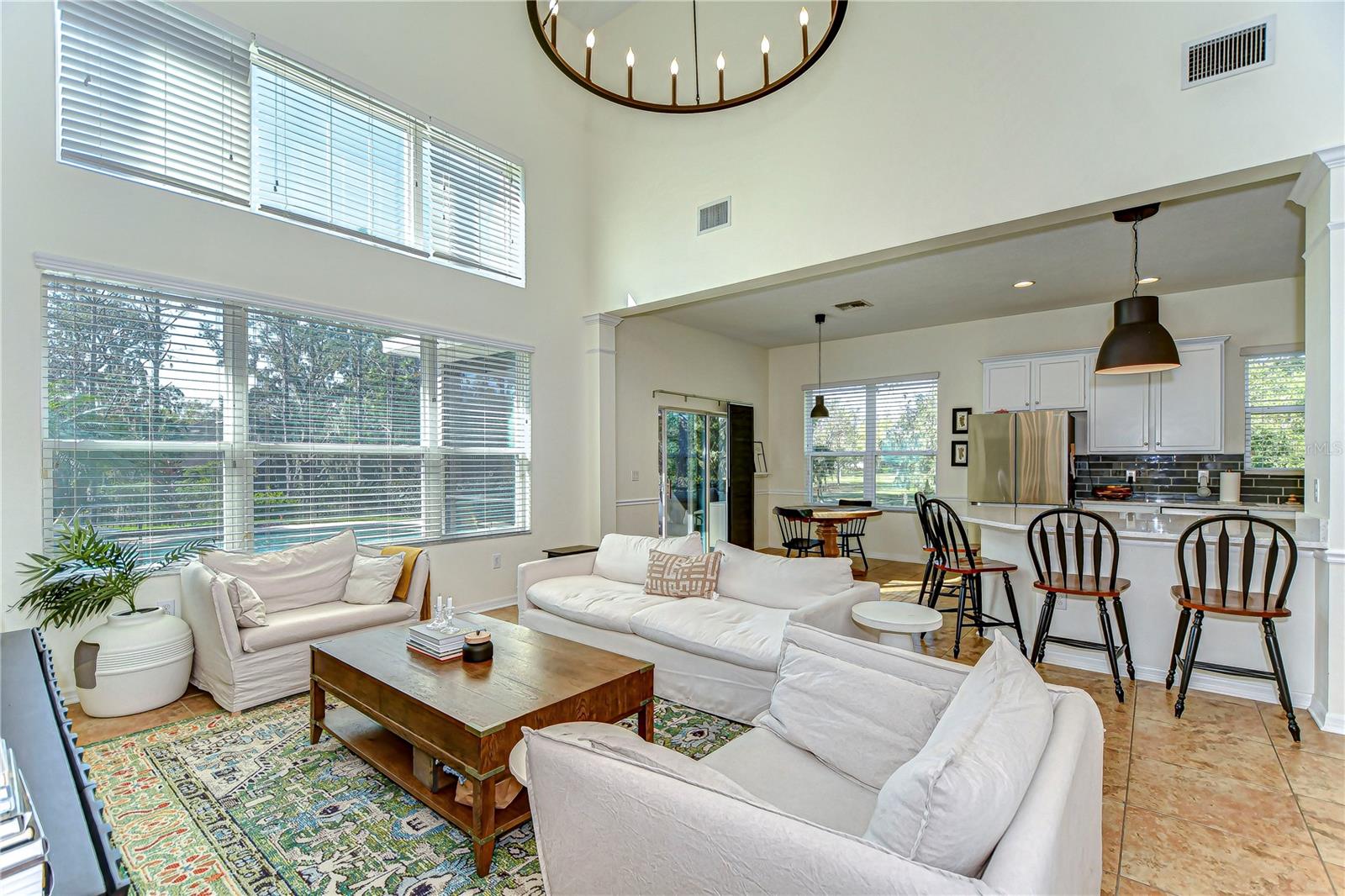 Oversized windows drench the room in natural light, seamlessly connecting to a modern kitchen perfect for culinary adventures.