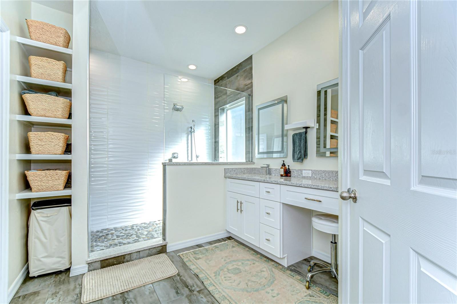 Step into luxury with this modern bathroom, featuring a sleek , elegant vanity, and convenient built-in shelving.