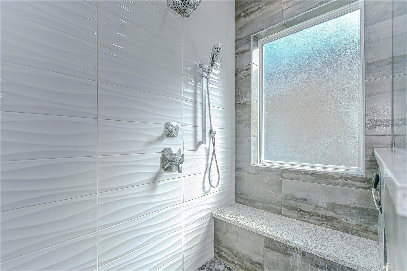 Step into tranquility with this elegant shower, showcasing modern wave tiles