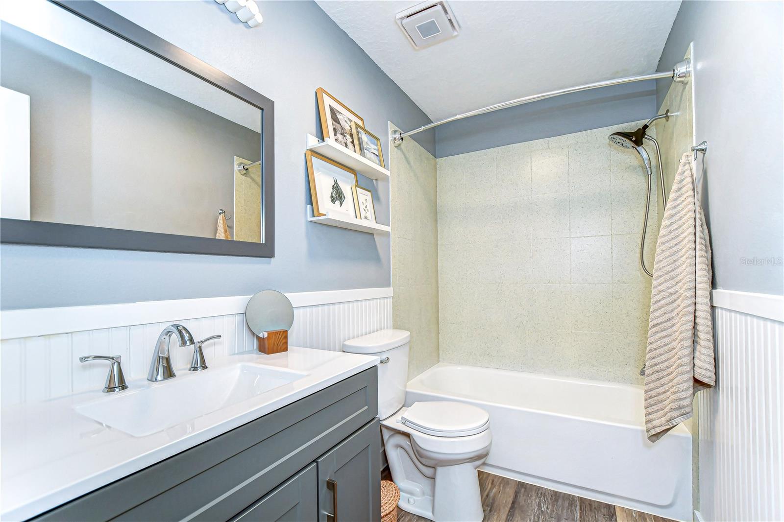 This bathroom combines style and function with a sleek vanity, modern fixtures, and a relaxing tub.