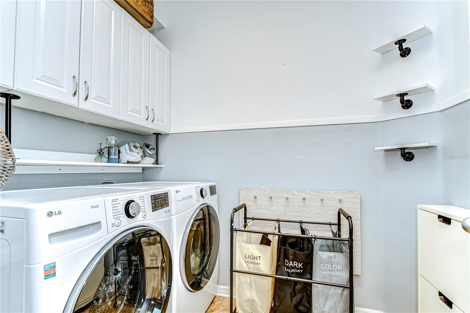 Effortlessly tackle laundry day in this stylish, spacious utility room featuring ample storage, and clever sorting solutions.