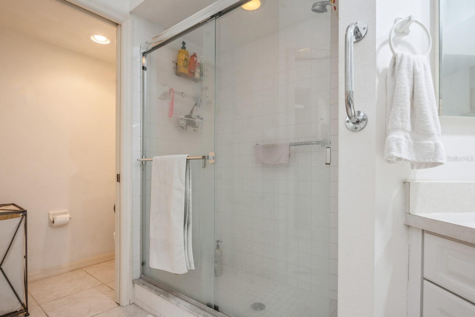 Primary bath features tucked away commode and walk-in closet