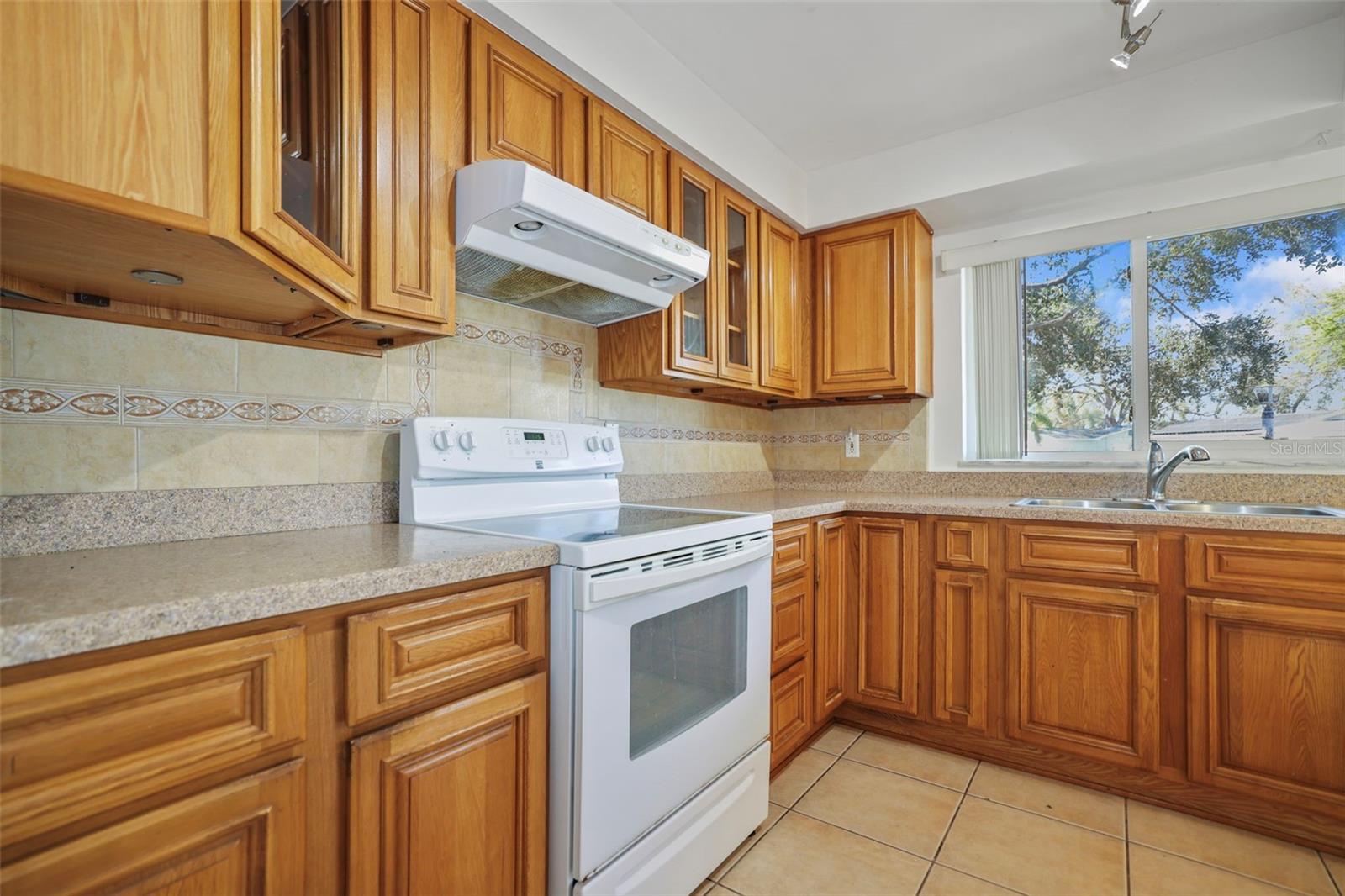 Kitchen with coiffured ceiling, tile floors and view to large front yard