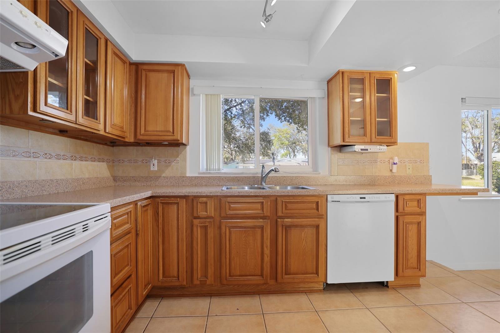 Kitchen with coiffured ceiling, tile floors and view to large front yard