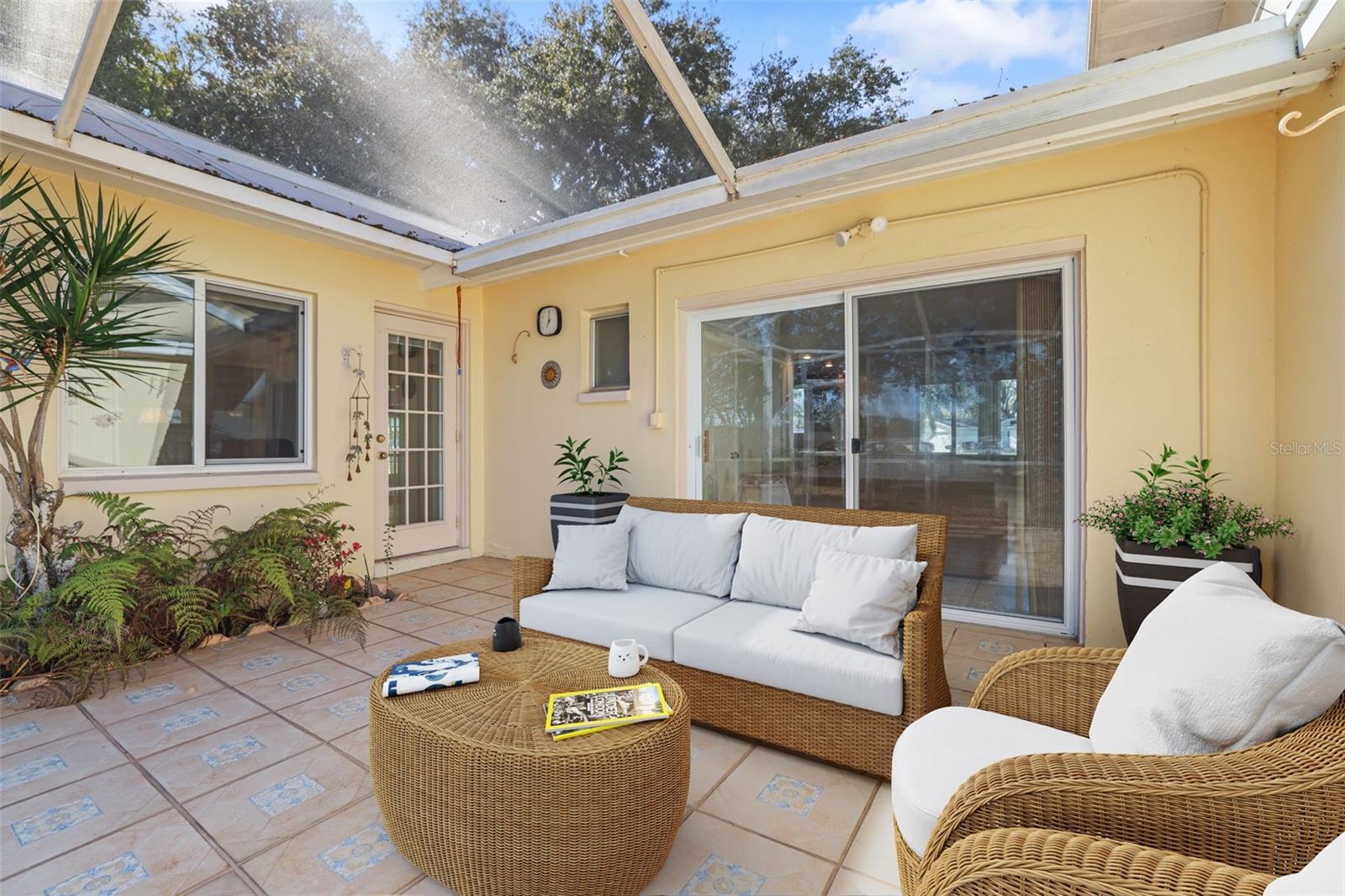 Screened lanai with view through to the lake and the backyard. Virtual Staging.