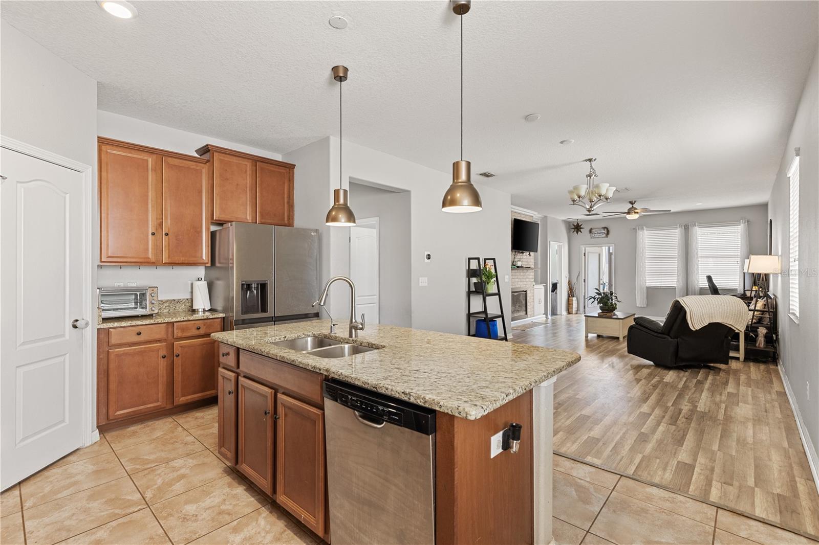 The kitchen, dining, and living areas flow seamlessly, featuring granite countertops