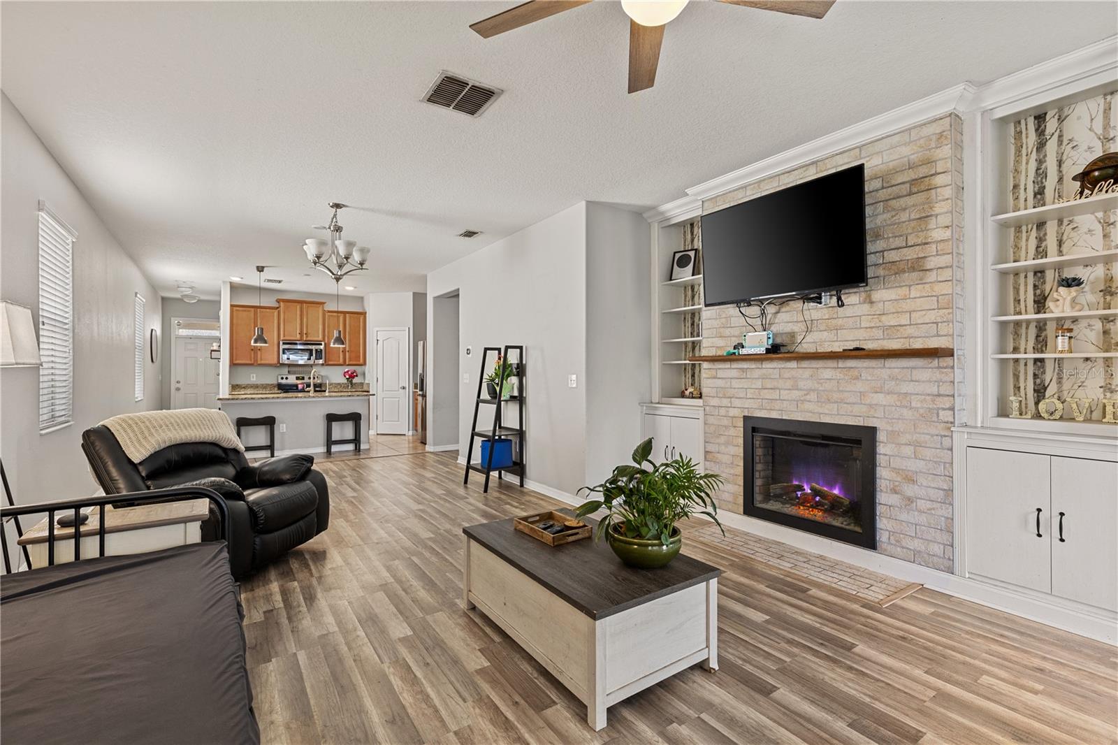 Beautiful accent wall with an electric fireplace with bookshelves on each side—perfect for showcasing décor, books, or cherished keepsakes.