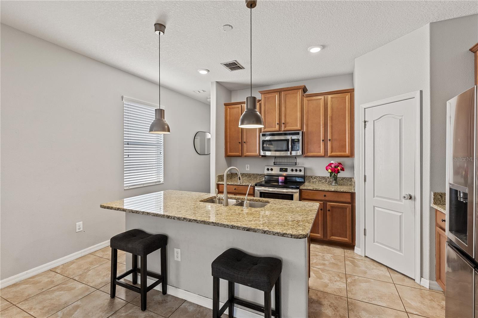 Featuring a spacious island for four, a pantry closet, and ample cabinetry.