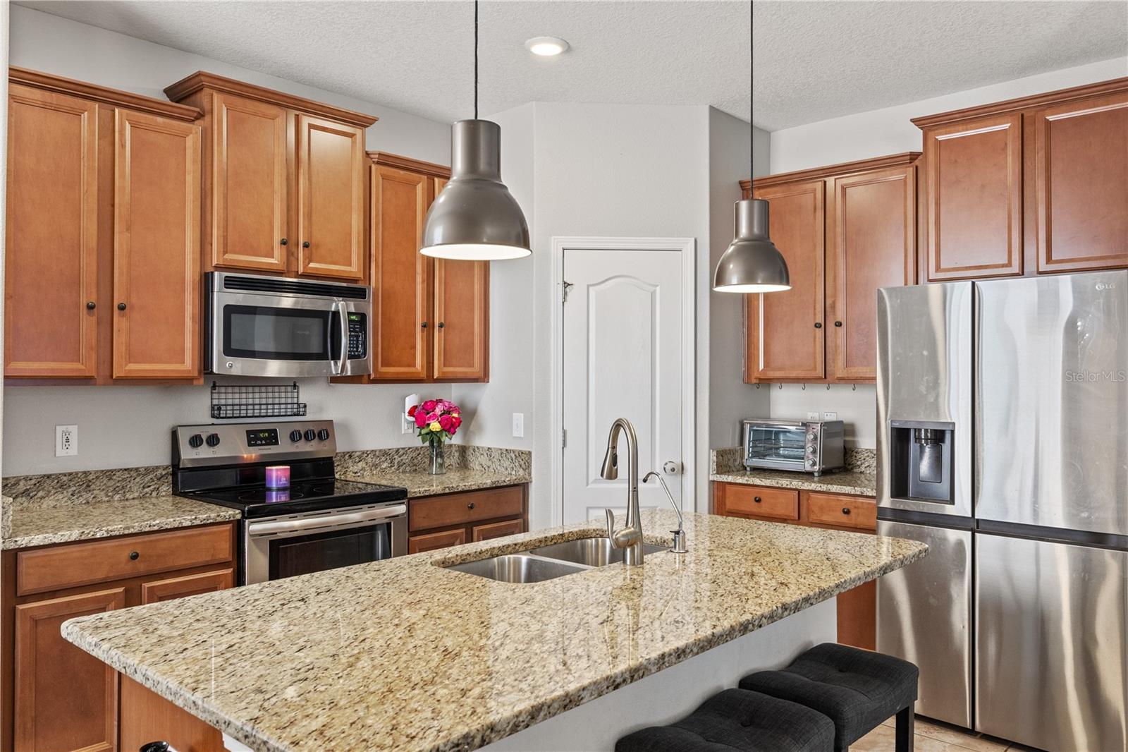 Featuring a spacious island for four, a pantry closet, and ample cabinetry.