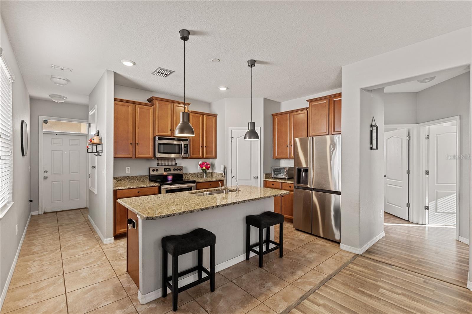 The kitchen, dining, and living areas flow seamlessly, featuring granite countertops