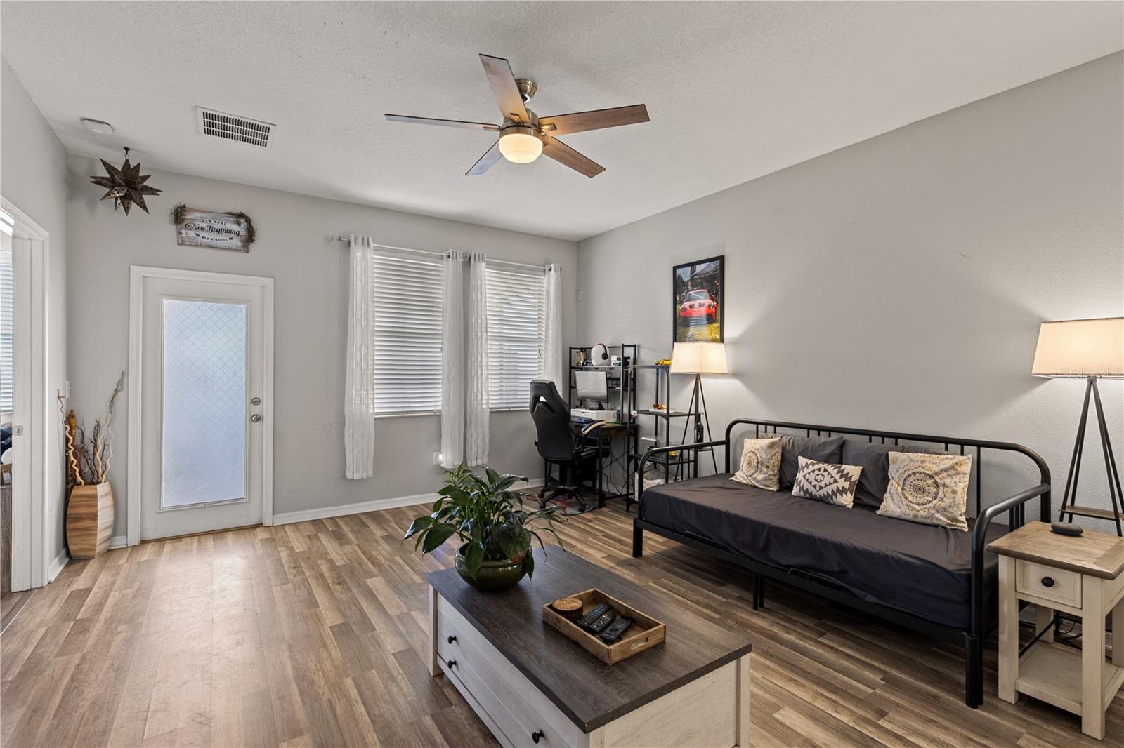 The large windows overlooking the screened-in lanai and fenced backyard with a 7x7 storage shed.